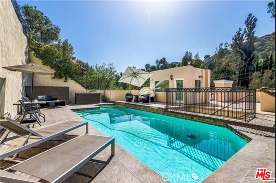 Available now is this spacious and luxurious 3,700+ square foot, 4-bedroom, 4-bathroom house on Benedict Canyon in prestigious Beverly Hills. The formal entry welcomes you with marble and stone floors, leading into a spacious interior featuring high ceilings, abundant natural light, and a cozy double-sided fireplace. The gourmet kitchen boasts stainless steel appliances, ideal for culinary enthusiasts, while the hardwood-floored bedrooms provide a warm and inviting retreat. The rooftop pool and spa create a serene oasis great for entertaining, complemented by central AC and heat throughout the home. A separate ground-floor bedroom adds privacy and flexibility.  With four dedicated parking spaces and a prime location just minutes from Beverly Hills' premier shopping and dining. contact us today for a private viewing.