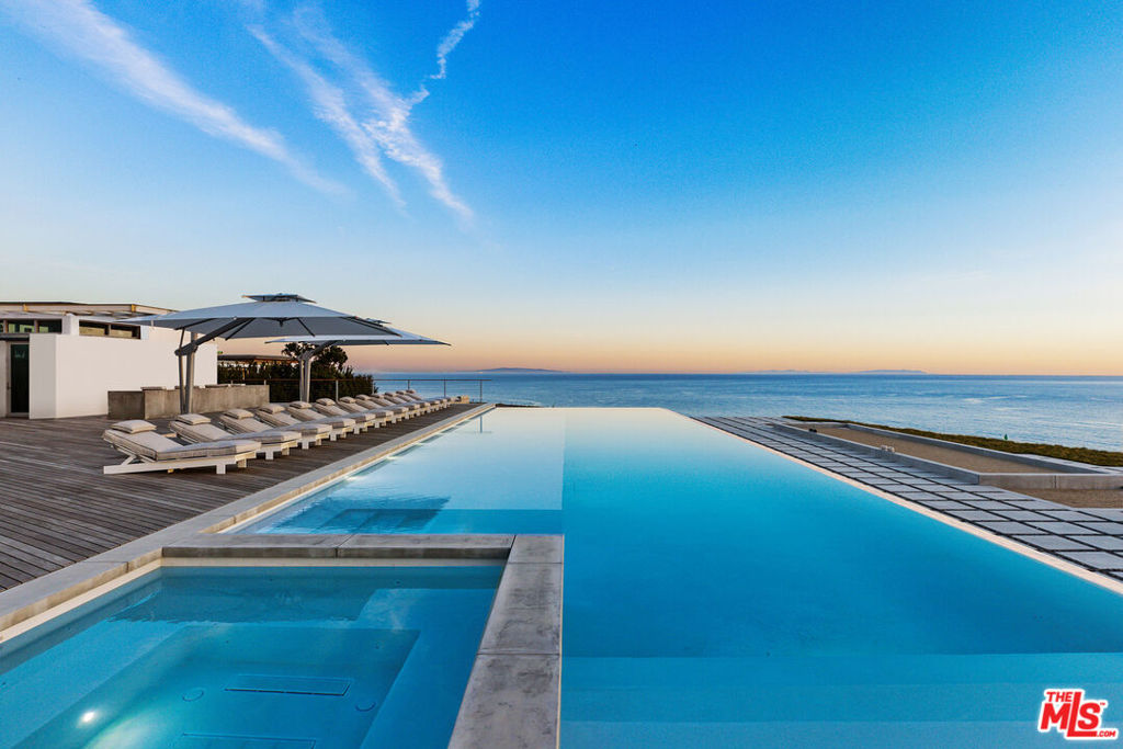 Welcome to The Edge, the first offering at The Case, a private, 24-hour guard gated community of five newly constructed mid-century modern inspired estates perched above Malibu Colony Beach. On 2.6 acres, this new state of the art fully furnished turn-key blufftop architectural estate showcases masterful craftsmanship throughout its 5-bedroom, 8-bathroom 10,527 sq. ft. expanse. With 13' ceilings surrounded by walls of glass opening to the approx. 75' infinity edge, freshwater pool and the 10,000 sq. ft. wrap around Ipe wood deck featuring an outdoor kitchen and cabana, the home erases the line between indoor and outdoor living, ideal for the coveted Malibu lifestyle and the fulfillment of any entertainer's dream. This timeless retreat features solid teak finishings, including an oversized teak entrance door, signature hand-hewed, aged white oak floors and custom tiles and cabinets. The primary suite includes a sheltered 500 sq. ft. terrace creating a spa-like oasis and a bathroom with a period-correct terrazzo floor. Awe-inspiring unobstructed sunrise to sunset panoramic views, The Edge features curated custom and original Unvarnished furnishings, a bespoke Bulthaup chef's kitchen with Miele and Gaggenau appliances, an 800-plus bottle wine room, a state-of-the-art media room and an attached en-suite bonus room accessible through a separate, private entrance. Minutes from Malibu's world-class dining and shopping, the owner of The Edge, will be one of the fortunate five to experience an unparalleled lifestyle, in the most exclusive and never to be duplicated enclave on the California coast.
