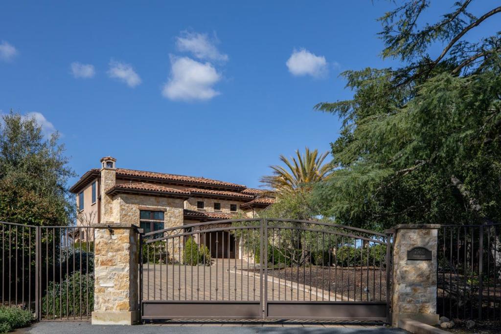 Newly Priced to Sell! This luxurious rustic Mediterranean estate is an exceptional property on more than one acre of beautifully landscaped grounds, complete with a Pinot Noir vineyard and bordered by the Packard Foundation orchard. Refined craftsmanship is evident throughout, with hewn beams, travertine finishes, and iron chandeliers enhancing every detail. The expansive two-story home features 5 bedrooms, an office, and 4.5 baths, complemented by impressive formal spaces and a fabulous kitchen and family room ensemble that opens to a covered loggia with heaters, built-in barbecue, and fire pit terrace. Adding to the allure are views out to the Bay, the 49ers stadium, and the Valley, along with the serene backdrop of the adjoining 60-acre Packard Foundation apricot orchard. This property, located just two miles from downtown Los Altos, offers privacy, prestige, and convenient access to top-rated Los Altos schools, making it ideal for Silicon Valley living. Proposed drawings for a 1 bed 1 bath ADU on property!