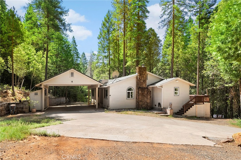 Peace and pines set on 2.24 serene acres in Magalia, this property blends natural beauty with practical upgrades. From the back deck, you can hear the gentle rush of the flumes, a peaceful reminder you're tucked into the best of mountain living.
Inside, you’ll find fresh paint, new carpet, and a hand-laid brick fireplace that anchors the living room with warmth and charm. The stunning fireplace is the kind of centerpiece that makes you want to light a fire, pour a cup of coffee, and stay a while. The layout includes generously sized bedrooms, a primary suite with its own bathroom, huge windows and plenty of storage throughout.
With a clear well and holding tank, clear termite report, detached workshop, covered carport, and a truly move-in-ready feel, this home offers comfort, space, and quiet simplicity surrounded by trees and fresh mountain air.