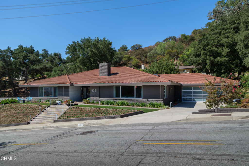 Welcome to this stunning, custom built, single level 1969 modern sited on a raised knoll in one of Glendale's most coveted neighborhoods just above the Oakmont Country Club and Golf Course. This home has been impeccably remodeled throughout and offers an open floor plan with an idyllic layout for both the relaxed California lifestyle as well as elegant entertaining. You enter via a stately foyer that connects the expansive living room, wrapped in windows, with thespacious entertainment room featuring a gorgeous fireplace and hearth done in tall porcelain tileframed by built-ins. All this leads into the open kitchen and dining area that beckons you outsidethrough tall glass doors to the covered patio space with an outdoor kitchen and tranquil rear yard. It is truly picture-perfect. Other highlights include a fully renovated kitchen with a large center island, quartz countertops, high-end appliances, a breakfast area, gleaming cabinetry and incredible fixtures. No detail has been overlooked and it shows! The three sizable bedrooms are beautifully appointed, including the light-filled primary suite with a walk-in closet as well as a fabulously updated bath. This home transports you and instills a feeling of escaping to your own luxurious private spa or retreat. The property offers a wide lot with exquisite curb appeal that showcases drought tolerant plantings, a verdant backdrop and peaceful treetop vistas. Don't miss this opportunity to buy a turn-key residence, in a sought-after area, with all the best amenities. This is a true showstopper and not to be missed!