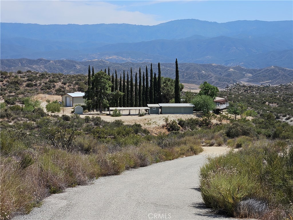 (Owner May Carry with 1/2 down and acceptable terms) Nestled in the scenic Sage hills area just outside of Temecula, this beautiful 5-acre rural property offers an opportunity to embrace country living without sacrificing convenience. Surrounded by expansive parcels, this property is a private island with panoramic mountain views and endless possibilities. A long, private driveway off paved Sage Road leads you to a view home, an impressive 26 X 35 steel workshop, and multiple outbuildings—ideal for storage, hobbies, or homesteading ventures. Perfect for horse lovers, hikers, bikers, or anyone seeking wide open spaces, the land offers room to roam with trails, mature shade trees, and tranquil sunset vistas from the wraparound deck. Recent upgrades include fresh exterior paint, new carpet, upgraded bathrooms and kitchen! Just a short drive to Temecula Wine Country and the city center, you're never far from fine dining, shopping, and entertainment. Outbuildings and kennels once used for the owner's dogs, the property features existing kennel facilities that could be repurposed as a rescue center, dog boarding, or a safe haven for your own pets (buyer to verify all possible uses). Whether you're dreaming of a peaceful retreat, homesteading lifestyle, or small-scale equestrian setup, this unique property is ready to help you bring those dreams to life. More photos and a full description coming soon! Showings will begin approximately two weeks from Friday, May 30th.