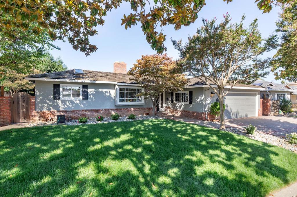 A classic home with large, open-concept living spaces fit for family living and entertaining with a manicured backyard that wraps around three sides of the home and provides ample space to dine, relax, and play alfresco. A pebblestone and brick walkway leads past a lush front lawn shaded by a Magnolia, Crape myrtle, and a Japanese maple at the covered entrance. Inside, the foyer introduces beautiful hardwood floors and a designer color palette that extends throughout. The kitchen, which overlooks the front of the house, has a dining nook, granite countertops, abundant cabinetry, and premium appliances. A sliding glass door leads out to the back patio, yard, and barbecue area. The family room sits open to the kitchen with a large picture window, while the separate living room enjoys a painted-brick fireplace and wide sliding glass doors to the backyard. The bedroom wing features three bedrooms, including the primary suite with a granite-appointed bath and access to the outside. The manicured yard has a vast stretch of level lawn, mature shade trees, a large partially-covered patio, a built-in brick barbecue island, raised garden beds, and a large storage shed. A timeless home on a picturesque street in the sought-after Waverly Park neighborhood!