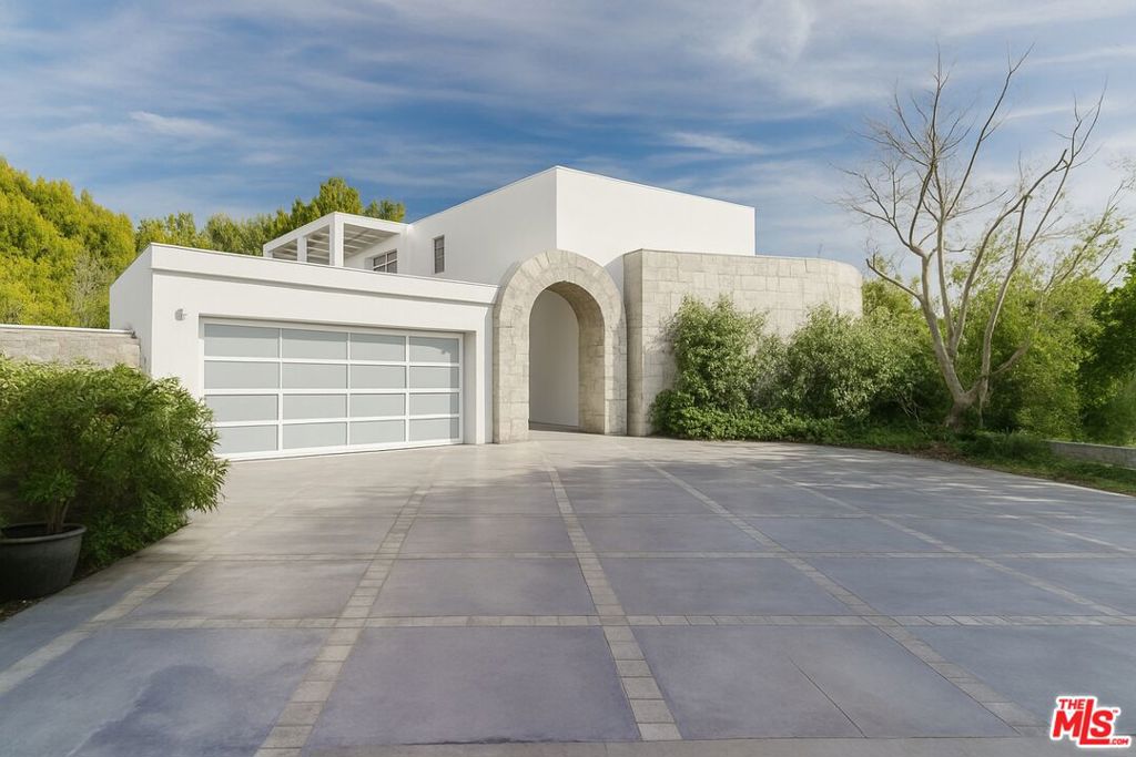 1111 Bel Air Place is an architectural masterpiece designed by the acclaimed Gus Duffy. Perched atop a private, gated cul-de-sac, spanning 6,446 square feet on an expansive 38,782-square-foot lot, this exceptional residence commands breathtaking panoramic views stretching from the canyons to the city skyline and Catalina Island beyond. Designed with soaring 10- to 12-foot ceilings and expansive walls of mahogany-framed glass, the home seamlessly integrates its surroundings while maintaining a striking sense of scale and openness. The main level features an opulent chef's kitchen with top-tier appliances, an elegant dining room, and a spacious family room, all opening to a front-facing balcony. Two en-suite bedrooms, a guest/maid's quarters, and a laundry room complete this level. A sculptural staircase leads to the upper floor, where the primary suite offers a private retreat with a sitting area, fireplace, dual walk-in closets, and two spa-like bathrooms, each with a walk-in shower and access to a rear-facing balcony with dramatic downtown views. An additional en-suite bedroom completes the second level. The outdoor spaces are designed for both serenity and entertaining, featuring a heated pool with an automated canopy, spa, waterfall, gas fire pit, and an outdoor kitchen with a built-in BBQ and pizza oven. Surrounded by lush landscaping, mature fruit trees, and vegetable gardens, this secluded oasis is both tranquil and self-sustaining. Additional amenities include an elevator, a state-of-the-art smart home system, surround sound, recessed lighting, a backup generator, a central vacuum system, and a secured stainless steel entry gate. A spacious four-car garage provides ample parking. A rare offering in one of the world's most iconic neighborhoods, 1111 Bel Air Place is a statement of refined living, where striking architecture and unrivaled views converge in perfect harmony.