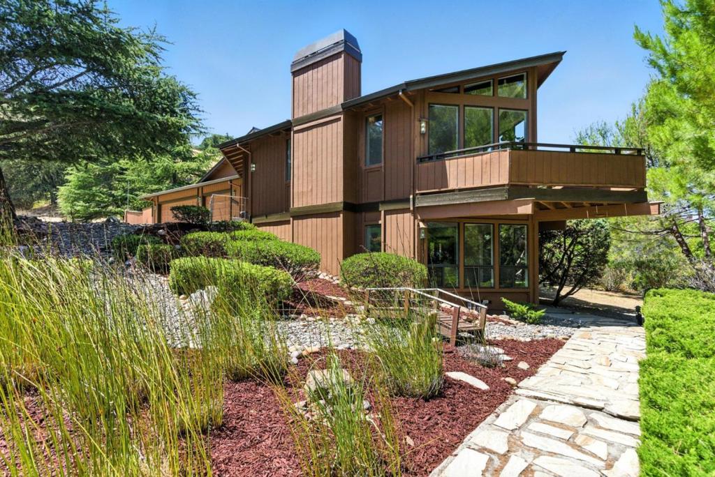 Exclusive Parker Ranch Saratoga! Nestled at the top of a knoll, this exquisite residence offers stunning valley and mountain hill views from most windows. Spanning 3,257 square feet on 1.75 acres, this home provides a private retreat while being perfectly situated in a serene cul-de-sac. As you arrive, a circular driveway welcomes you to a grand entrance featuring a skylight. The interior, adorned with carpet throughout, boasts a blend of formal and casual spaces, including a formal dining room with ample windows and a step-down living room with fireplace, exposed wood beams, and a marble-countered wetbar. The gourmet kitchen is a chefs dream, complete with a center island, professional-grade vent, double electric stovetop, and built-in Sub-Zero refrigerator. The large breakfast nook, surrounded by windows, offers a glass-room feel, perfect for enjoying morning coffee with valley views. The primary features access to a covered balcony, expansive walk-in closet with built-ins, and a luxurious en-suite with a large stall shower. Additional amenities include a three-car garage with a full workbench, a downstairs family room with sliders opening to the grounds, and a covered patio. Experience the epitome of elegance and tranquility in this remarkable Saratoga home.