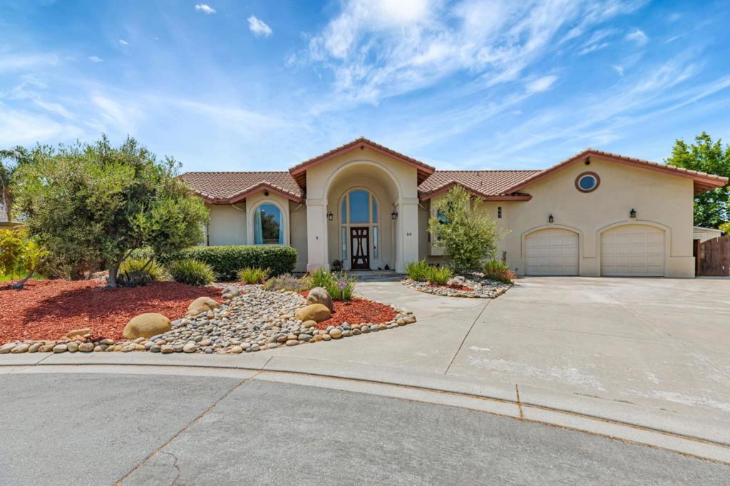Experience refined living in this beautifully appointed home with scenic views and exceptional detail throughout. Step through a custom front door to find Kaleo and Tuscan maple tile flooring, custom louvered shutters, skylights, French doors, and wrought iron chandeliers. The living room features vaulted ceilings, a gas fireplace, built-in lighted niches, and French doors leading to a spacious deck. The chefs kitchen boasts a large island with Wolf cooktop, prep sink, mosaic backsplash, ample storage, and a walk-in pantry all with amazing views. The primary suite offers vaulted ceilings, dual walk-in closets, outdoor access, and a remodeled spa-like bath with a curb-free shower, fusion blue quartz counters, oak cabinets, and antique-style hardware. The guest bath includes Valeria black slate tile with river pebble accents, tile floors, dual sinks, and blue tempest quartz counters. The fourth bedroom doubles as a home office. A bi-level bedroom provides attic access with built-in workbench. Enjoy your private backyard oasis with a firepit, covered porch with fan, and avocado trees. A dedicated golf cart garage adds extra convenience. This home blends luxury, comfort, and charm, perfect for executive living or family life. Call your favorite REALTOR® for a private tour.