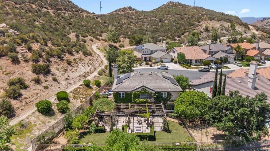 Welcome to 27792 Elderberry Street, a beautifully upgraded home situated in one of the most desirable locations within Greer Ranch—a prestigious, guard-gated community known for its tranquil surroundings, panoramic views, and resort-style amenities. Residents enjoy access to a sparkling pool, scenic parks, miles of hiking and biking trails, and impeccably maintained grounds.  This move-in-ready residence showcases an expansive floor plan designed for both everyday living and stylish entertaining. Step inside to discover travertine flooring, fresh designer paint, and curated finishes throughout, including a touch of sophistication with Gucci wallpaper in the downstairs powder room.  The gourmet kitchen seamlessly connects to the open-concept living and dining areas, flowing effortlessly into a private backyard oasis. Here, you'll find a built-in gas BBQ, an outdoor refrigerator, and a cozy fire pit area—perfect for entertaining or relaxing under the stars. The drought-tolerant front yard keeps maintenance minimal, while the backyard boasts nine mature, fruit-bearing trees and a custom garden area, ideal for enjoying your own farm-to-table lifestyle.  Additional highlights include a whole house fan (installed in 2020), a brand new water heater (2024), and a maximized solar panel system for superior energy efficiency. The garage is EV-ready with a 220V outlet and features overhead storage for added functionality. For everyday ease, the laundry room is conveniently located upstairs. Just steps from scenic trails and minutes from shopping centers, restaurants, and freeway access, this home combines privacy, comfort, and convenience in one exceptional package. Don’t miss your chance to own a modern retreat in one of Murrieta’s most exclusive communities.