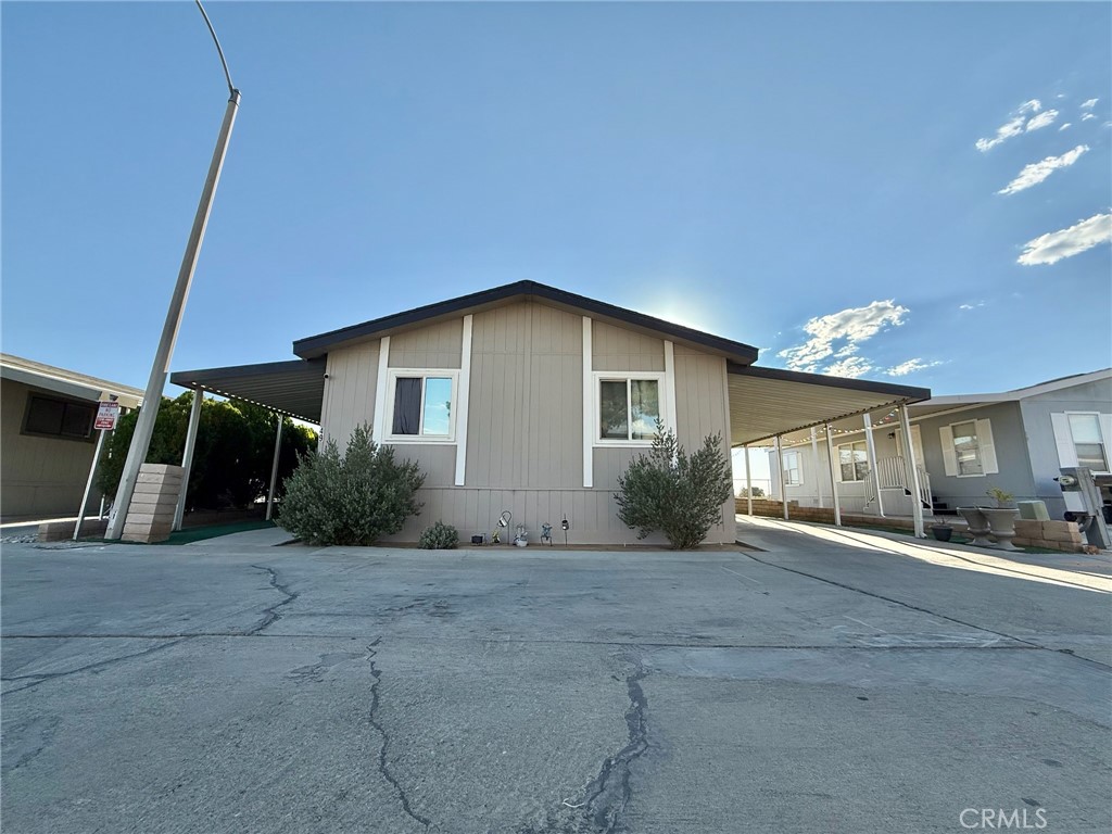 Welcome to this spacious and well-maintained 3-bedroom, 2-bathroom mobile home featuring a versatile bonus room, perfect for an office, playroom, or extra living space. The open-concept kitchen includes a large island, ideal for entertaining. The master bedroom is privately situated on the opposite side of the home from the additional bedrooms, offering added privacy. Enjoy outdoor living with a covered front porch and a shaded carport that accommodates up to three vehicles. The backyard includes a private storage shed and a generous patio area, this home offers comfort, functionality, and space at an affordable value.
