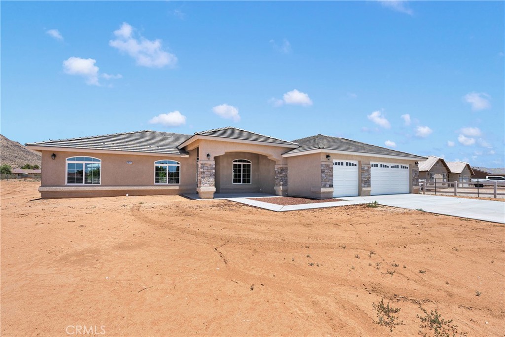 This property qualifies for the exclusive NAF Pathway Program, offering a significantly reduced interest rate, NO mortgage insurance, and up to $8,000 in buyer assistance—a rare opportunity to save big on one of the most move-in-ready homes on the market! This brand-new construction home offers a spacious and modern design, featuring 4 bedrooms, 2 full bathrooms, and 1 half bath. The open floorplan seamlessly connects the living spaces, creating an inviting atmosphere. The split bedroom layout ensures privacy, with the main suite separated from the other rooms. The kitchen is a standout, boasting a large quartz waterfall island, complete with sleek pendant lighting above, offering both style and functionality. The dining area is adjacent, creating a great flow for friendly gatherings and entertaining guests. The expansive great room features a cozy fireplace, perfect for relaxing evenings. Throughout the home, you'll find beautiful, tiled flooring in the main areas, including the hallways, bathrooms and laundry, while the bedrooms are comfortably carpeted for added warmth. The main suite is a true retreat, offering a separate shower, along with a generous walk-in closet for ample storage. In addition to the stunning interior, this home comes with an oversized 3-car garage, providing plenty of space for vehicles and storage. Large rear patio for extending living space. Set on a large 1-acre lot, you'll have plenty of room to enjoy the outdoors, add an ADU or whatever strikes you. PAID FOR SOLAR. The property is conveniently located near major interstate easy access to the I-15, shopping, and schools, making it a perfect location for convenience and comfort.