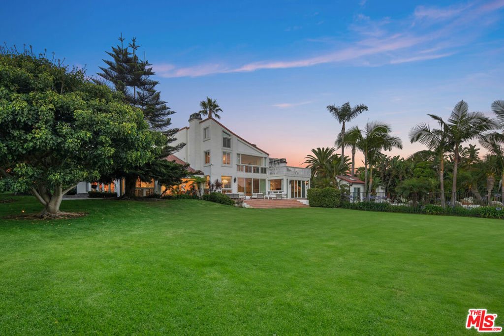 Set on 2.3+ acres of flat land in prime Malibu, this gated contemporary Mediterranean compound offers luxurious living with stunning ocean views and enormous grassy lawns. The estate provides privacy, security, and ample space with 6,200+ sq. ft. of interior living including 6 bedrooms and 7 bathrooms. Finished with the finest materials, the home is bathed in natural light from large windows that overlook the verdant grounds and the magnificent Pacific Ocean. The formal living room centers around a cozy fireplace, while the updated kitchen boasts superior stainless steel appliances and ample counter space. The living area opens to a private terrace with a sparkling, oversized swimmer's pool and spa. At the base of the lot, find a Hawaiian-landscaped garden with full palms, manicured lawns, and wide-open spaces perfect for various activities including gardening, sports, or the potential for equestrian facilities or future development (buyer to verify). The primary suite features his and her ensuite baths, two walk-in closets, and a private sitting room, along with access to an upper private deck where you can enjoy breathtaking sunset vistas and tranquil nights. Parking includes a 3-car garage with 6 additional driveway spaces. This luxurious legacy estate is conveniently located just moments away from Zuma Beach, grocery stores, shopping, restaurants, and Malibu High School.