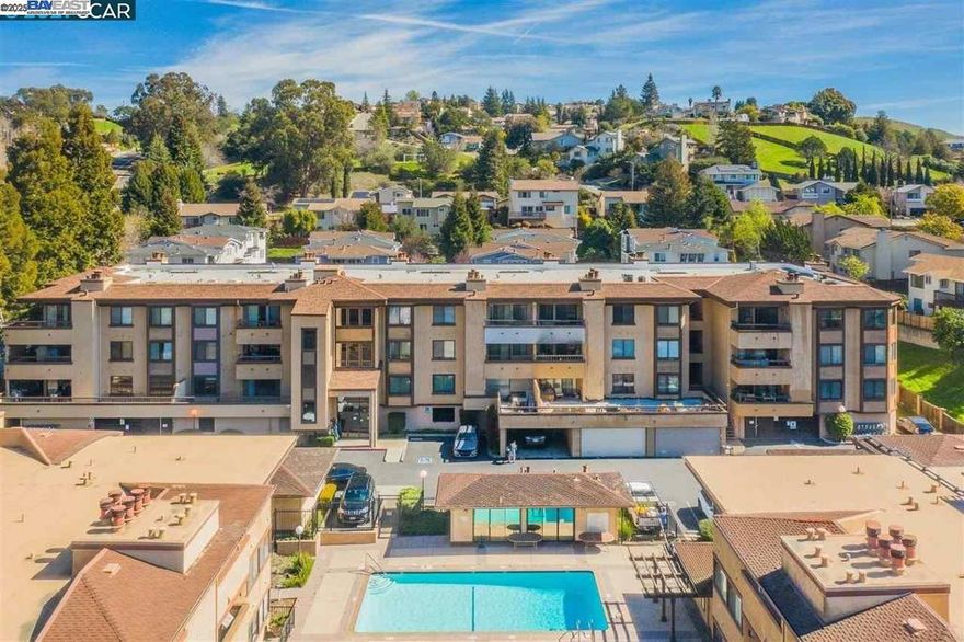 Discover an exciting opportunity! Beautifully updated home in the Hayward Highlands’ most sought-after condo communities. Stylish home over 1,200 sq. ft. of bright, modern living just minutes from Cal State East Bay, Castro Valley dining, local Farmers Market, scenic parks, hiking trails,& Bay Area.Step inside & find thoughtfully upgraded finishes throughout, a fireplace, granite countertops, modern lighting, washer & dryer, laminate flooring, and central heat for year-round comfort. The spacious primary suite features dual closets, oversized L-shaped bathroom with a dedicated vanity area, creating a true private escape.Open-concept living room flows seamlessly to a private balcony overlooking the peaceful courtyard and sparkling pool—ideal for your morning coffee, work-from-home breaks, or evening relaxation.Updated kitchen offers generous cabinetry, plenty of workspace for cooking, or remote work. Features detached two-car garage, a rare find & one of only a few in the entire community. Enjoy beautifully maintained grounds, mature trees, a refreshing pool, included water and garbage, and a 24-hour elevator for added convenience. Move-in ready and surrounded by top-tier amenities mix of comfort, convenience, and resort-style living. This is a rare chance you won’t want to miss!
