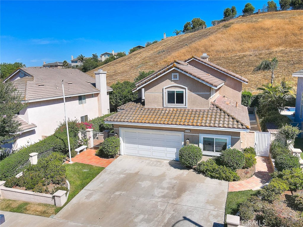 Located in a highly desired Chino Hills neighborhood, this 4 bedroom plus loft, pool/spa home is situated on a quiet cul-de-sac with extensive upgrades. You will appreciate the elegant, customized woodwork throughout, including wainscoting, rich wood paneling featuring custom built in closet & shelves in one of the downstairs bedrooms, coffered ceilings, base & crown moldings w/dentil accenting, alcove niches, ornate carved fireplace surround & custom front door. The formal living & dining rooms are spacious and perfect for gatherings. The family room, centered around the custom fireplace, provides an open layout onto the kitchen that features a large center island, tile countertops, decorative tile back-splash & offers plenty of storage. This floor plan features a downstairs bedroom with easy access to the upgraded 3/4 bathroom and the home's 4th bedroom currently being used as a den. Upstairs has a spacious loft that's perfect for an at home office. The primary bedroom has dramatic high ceilings with an ensuite bath featuring dual sink vanity, separate soaking tub, walk in shower & a walk in closet. The secondary upstairs bedroom has built-in shelving for extra storage or displays & direct access to a full bathroom. The private backyard features a sparkling pool & spa, an alumawood covered patio and offers plenty of room for entertaining. You don't want to miss the opportunity to make this your Dream Home!