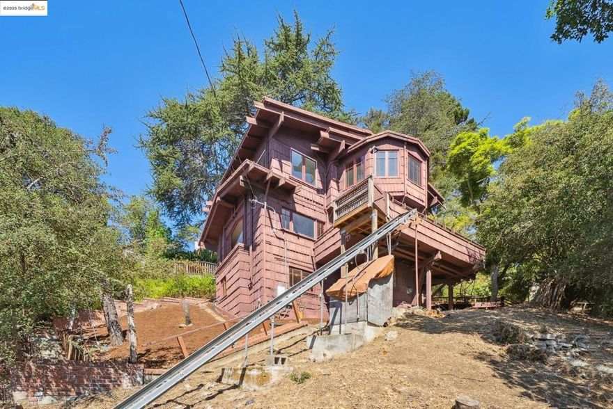 This Arts & Crafts era residence nestled in the Berkeley Hills offers the perfect blend of period charm, spacious living & breathtaking panoramic views of SF, Bay & GG Bridges, & Mt. Tam. Built in 1915, this thoughtfully designed 3++ bed, 2+ bath home sits on a massive 20,375 SF lot. The separate garage & driveway creates opportunities for a lot split or ADU. The main level with gorgeous oak floors offers a dramatic living room with period wood trim, warm brick fireplace flanked by built-ins & large picture windows to the sweeping Bay views. The dining room boasts box beams, built-ins & a wall of windows to fill the room with natural light. Enjoy the expansive woodsy setting & Bay views while dining & entertaining on the wraparound balcony. The kitchen has ample cabinetry & opens seamlessly to nature-filled back decks. A lower level guest suite, complete with kitchenette & full bath makes it perfect as a casual family room, home office or in-law suite with both interior & separate exterior entry.  Just minutes to No. Berkeley restaurants, shops, farmer's markets & vibrant downtown. This exceptional property is ready for your inspiring vision & updating with endless opportunities to expand & take advantage of the private hills setting & views.