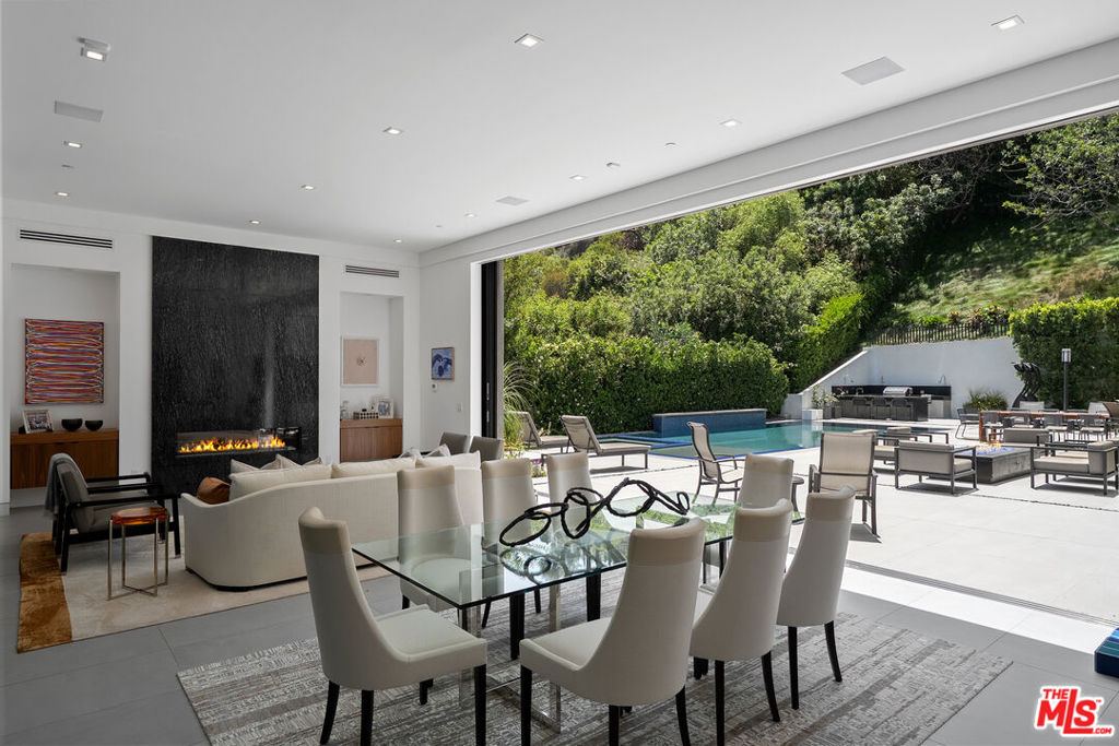 Located just minutes from the world famous Sunset Strip with all the shops, dining, and entertainment at your fingertips. This home boasts an abundance of natural light, and an open floor plan that seamlessly transitions from indoor to outdoor living through floor to ceiling pocket doors. The wide open kitchen includes professional grade appliances, a dumbwaiter, and a back prep kitchen with commercial grade stove/oven. Downstairs you will find an entertainers dream that includes a theater, gym, sauna, guest room, wine cellar, and wet bar. Additional features include a luxurious primary suite with gorgeous views and resort-like amenities, an office, and three additional spacious bedrooms. The expansive backyard oasis comes complete with indoor/outdoor bar, sparkling pool with Baja-shelf and spa, fire pit, outdoor kitchen/BBQ, and ample space for dining and relaxation. Soak up the sun or enjoy breathtaking views from the large rooftop deck with fire pit and the expansive balconies from most bedrooms. This property is not to be missed. This home has it all. Available immediately.