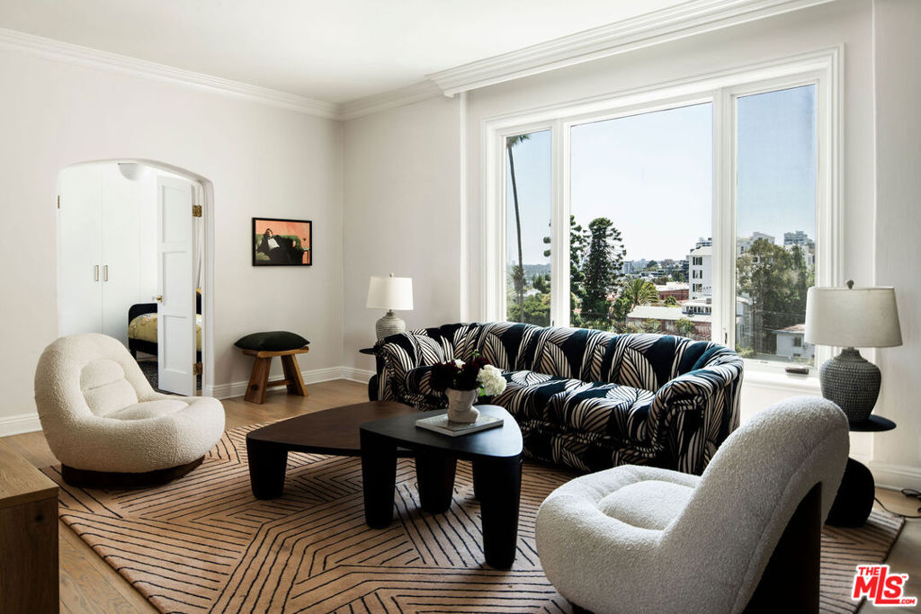Experience timeless elegance and sweeping, panoramic viewsfrom Downtown to Century Cityin this beautifully updated fifth-floor residence at the iconic Granville Towers. Ideally positioned within the building, this unit enjoys rare unobstructed East and West exposures, allowing you to watch the sunrise from the primary bedroom or dining room, and take in breathtaking sunsets from the living room. Seamlessly blending modern luxury with Old Hollywood charm, this two-bedroom residence features a versatile floor plan that includes a formal dining room or optional den. Generously scaled rooms offer high ceilings, rich wood flooring, and top-tier finishes throughout. The separate kitchen is thoughtfully designed with premium appliances, including a Thermador range, Viking refrigerator, built-in microwave, stone countertops and a stacked washer/dryer. A distinguished example of French Normandy architecture, Granville Towers was designed by renowned architect Leland Bryant in 1930. Steeped in Hollywood history, it has served as a retreat for icons such as Marilyn Monroe, Rock Hudson, Nora Ephron and David Bowie. Perfectly positioned in the heart of the Sunset Strip, it's just moments from landmarks like Chateau Marmont and Sunset Tower, as well as top-tier dining, nightlife, shopping, and premium markets including Whole Foods, Trader Joe's, and Bristol Farms. This turnkey home is nestled in a full-service, pet-friendly gated building offering a doorman and lush, meticulously maintained English gardens. A rare opportunity to own a piece of LA history with the best seat in the house. Can be sold fully furnished.
