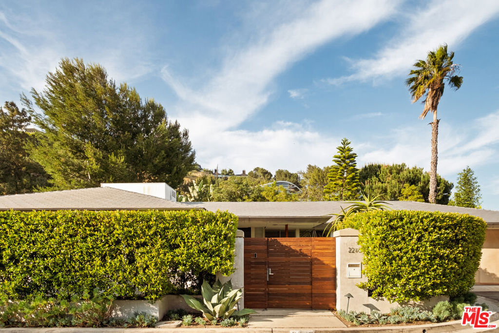 Tucked at the end of a quiet cul-de-sac in the prestigious Outpost Estates, this rare Mid-Century Modern residence is a work of architectural heritage and timeless design. Conceived by notable architect, Dennis Wehmueller, a protge of Frank Lloyd Wright and the architect behind the Los Angeles Municipal Art Gallery among other well-known post war projects. This home reflects the principles of organic modernism seamlessly merging structure, landscape, and light. Sensitive updates preserve the integrity of its original design while enhancing comfort with today's refined luxuries.The property is situated just minutes from Hollywood and the Sunset Strip, yet profoundly removed from the city below. Set behind tall, mature hedges, the home functions as its own private sanctuary. The interiors boast garden views from every vantage, drawing you outward and inspiring private outdoor entertaining. Walls of glass dissolve boundaries between interior and exterior, flooding the living spaces with natural light and framing panoramic views of Runyon Canyon and the surrounding hills. Inside, authentic modernist details polished concrete floors, custom cabinetry and Bisazza tile, combined with radiant-heated floors, coved lighting, and custom built-ins to create a warm, sophisticated environment. The open plan flows effortlessly from the living room with fireplace to the dining area and sleek kitchen, extending out to a covered terrace for year-round indoor/outdoor living.Electronic window shades, an advanced media system, and a two-car attached garage add ease and modern functionality. Surrounded by lush landscaping and tree top vistas, the property offers both serenity and significance a rare opportunity to inhabit a piece of Los Angeles' architectural lineage in one of its most sought-after neighborhoods.
