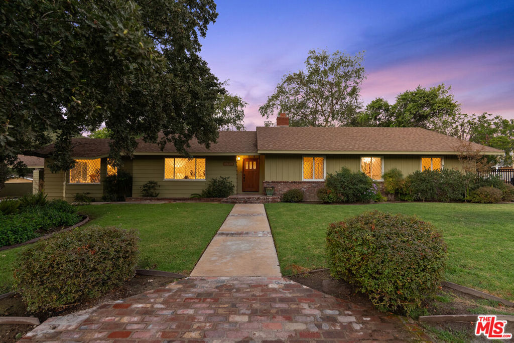 This extraordinary 5-bedroom, 4.5-bath estate, beautifully remodeled to perfection, is situated on a sprawling +-3/4 acre lot on one of Newhall's best streets, offering ample space and privacy. With 131 feet of frontage and a rare street-to-street lot, this home boasts exceptional curb appeal and an expansive layout. As you enter, you're greeted by an abundance of natural light streaming through exquisite diamond-beveled windows, which add a timeless elegance to the home. The interior features rich wood floors throughout, paired with plantation shutters, creating a warm and inviting atmosphere. The home is equipped with a multi-zone air and heat system, ensuring comfort in every room. The chef-inspired kitchen is a standout, featuring stainless steel appliances, sleek quartz countertops, and ample storage space, making it a dream for culinary enthusiasts. A true highlight of this property is the oversized 2-car garage, offering high ceilings that would easily accommodate a car lift, ideal for auto enthusiasts. For added convenience, there's a generous driveway with parking for 10+ cars, plus a large, covered carport, providing abundant parking options for guests or a growing family. Inside, every room is generously proportioned, with expansive living areas that are perfect for both relaxation and entertaining. The luxurious master suite is a retreat in itself, offering a private office/bonus room, a massive walk-in closet, and a spa-like bathroom complete with a separate soaking tub and a glass-enclosed shower. Throughout the home, every detail has been meticulously thought out, ensuring a seamless blend of comfort, style, and functionality. Outside, enjoy stunning views of Newhall, providing the perfect backdrop for quiet evenings or entertaining guests. This exceptional estate offers an unparalleled combination of luxury, space, and convenience all while being walking distance to Main Street highlighting Santa Clarita's best restaurants and entertainment!