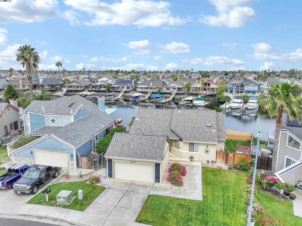 WATERFRONT SINGLE STORY! PRIVATE U-DOCK WITH METAL BOAT COVER AND AMPLE WATER SPACE FOR ADDITIONAL WATER TOYS - Open concept living area with Pergo flooring throughout - New interior paint - Kitchen w/SS appliances - Great room w/high vaulted ceiling, dining area & fireplace - Primary with water view and slider to access back deck, high vaulted ceiling, 3 closets, bath offers stall shower and dual sinks - Spacious back deck w/Trellis overhang plus fenced side yard w/grass & tool shed - Indoor laundry room - All this and more...