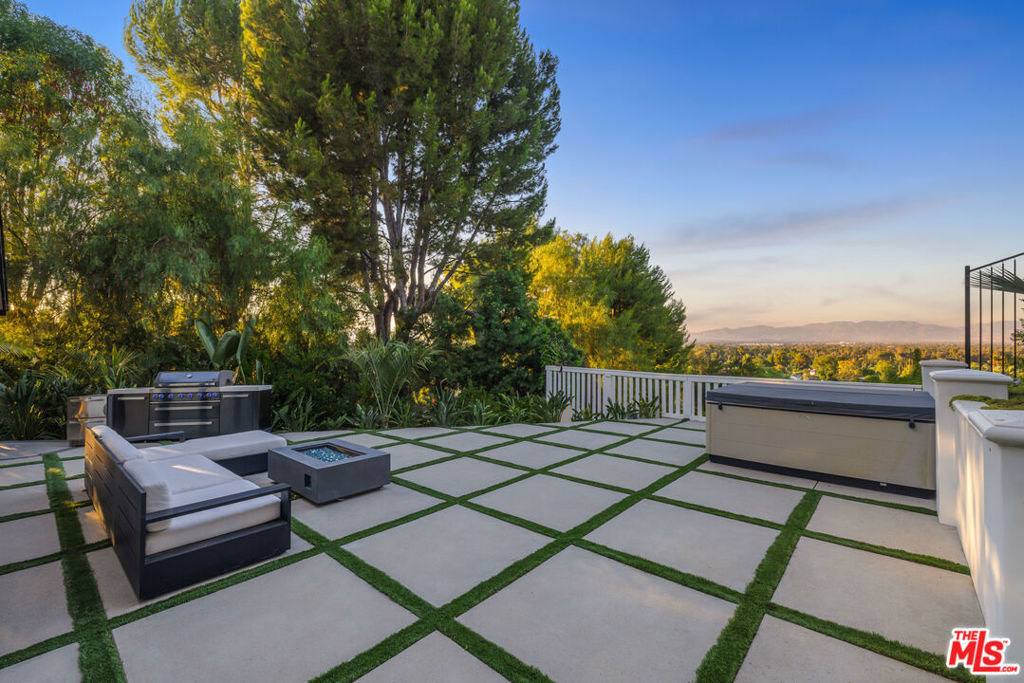 Nestled in the coveted Encino Hills, south of Ventura Blvd, this fully furnished, single-story contemporary retreat blends privacy, modern comfort, and effortless living. Situated at the end of a semi-private driveway and surrounded by mature trees, the home offers tranquil seclusion while remaining just minutes from the vibrant energy of the valley below. An open floor plan connects the living spaces to the backyard, with bi-folding glass doors creating a seamless indoor-outdoor flow. The spacious living room features vaulted ceilings and a fireplace that opens to the dining area and chef's kitchen. Natural light floods the interior, highlighting the rich wood floors and creating a warm, inviting ambiance throughout. The home offers three bedrooms, including a primary suite with a cedar-lined walk-in closet and a beautifully appointed en-suite bath. A versatile bonus room adds flexibility - ideal for a home office, gym, or media lounge. Multiple outdoor areas include a spacious dining patio along with zones for entertaining, a hot tub, and a fire pit - all perfectly positioned for sunset views or stargazing. Recently renovated, the home features updated electrical, plumbing, HVAC systems, and new windows with custom wood shutters, ensuring both efficiency and style. Additional highlights include motorized blackout blinds, a 6 speaker built-in Sonos system that extends into the backyard, motorized skylights, exterior security cameras with a full security system, and high-quality furniture from Arhaus and Restoration Hardware - making this home truly turnkey. Weekly landscaping and spa maintenance is included in the rent along with internet service and an eero mesh wifi network. Conveniently located near top-rated schools, with easy Westside access and proximity to shopping, dining, and Equinox, this hillside oasis offers the perfect balance of luxury, comfort, and convenience.