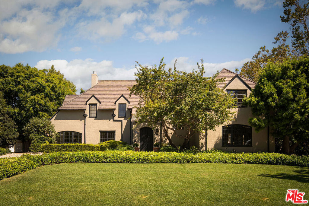 This stately home with incredible architectural elements, brings the best of historic architecture to Hancock Park. Built in 1920 by famed architect Arthur Rolland Kelly of The Playboy Mansion, for Arthur Letts Jr. of The Broadway Department Store family, it is one of the earliest residences built in the area still in existence. Character filled and timeless, this corner estate nestled on nearly a half an acre lot, is where Golden Era charm meets an idyllic garden retreat. It is no accident that it was once marketed in the 1920's as a "Beautiful English" and an "estate in the city". Perched high above famed Rossmore Avenue and set back from the street, your heart will soar the moment you arrive where you are greeted by stained glass windows, and pulled to a world of lush landscaping, perfectly placed pool, guest house and storied pedigree. Its unique L shaped layout leads you outside from many vantage points, and the floor plan has a remarkable ease and grace. Giving space where needed while always inviting loved ones together. Warm, natural light abounds throughout, reflecting off rich, peg and groove hardwood floors, welcoming you to an expansive front room complete with a handsome fireplace and carved moldings. Serenity continues as you drift away the days reading your favorite book in the solarium-like office, complete with floor to ceiling shelving, perfect for any bibliophile. Move into the expansive living room where you and yours can cozy up, hang and entertain adjacent to the kitchen & dining areas. Elegant and enchanting formal dining room with banquet and cabinetry makes for perfect gathering. Large, classic tiled kitchen with stainless steel appliances, French oval ceiling pot rack and center island, is a character rich delight. Large finished California basement provides 724 sq ft of additional usable space for storage (not included in square footage), future wine room and functionality. The downstairs level opens to the backyard off of three separate entrances for a true indoor outdoor experience, where an enchanted world of hedged privacy awaits a true oasis. Enjoy those long summer L.A. months perfect for al-fresco dining, entertaining and simply relaxing in your own in-ground swimming pool. Two tasteful guest bedrooms with full bath round out the first floor. Wind your way up the stairs via the handsome staircase with ornate carved wood banister to the second level where 4 large bedrooms and 3 baths, and cozy office await plus the most incredible upstairs entertaining room. The large Primary, complete with its own fireplace, dual walk-in closets, and its own ensuite bath, overlooks the hydrangea dotted backyard. Attached hallway office provides charming workspace privacy. Two additional bedrooms each with their own Juliet balconies, ample closet space, and side-by-side updated bathrooms combine to create a generous floor plan. Wind your way to a window rich entertaining room with a built in bench seat, fully functional as an additional creative, living or lounging space. Home is complete with 5 HVAC systems, upgraded alarm, detached garage and electric remote driveway gate for additional security. The home's unique corner location, and a second driveway with ample gated parking on 4th street makes entering and exiting the property easy for daily life. Detached, 530 sq ft Guest House with its own kitchenette, mini fridge, dishwasher, mini split HVAC and full bath is the perfect at-home office, workspace, or home gym. Boasting nearly 6000 sq ft and just blocks to the shops, restaurants and farmers market of Larchmont Village, Marlborough School and the best Hancock Park has to offer, this magnificent, iconic beauty is waiting for you to write your next chapter. Located in the Third Street School District and Hancock Park HPOZ. This truly is the special estate you have been looking for.