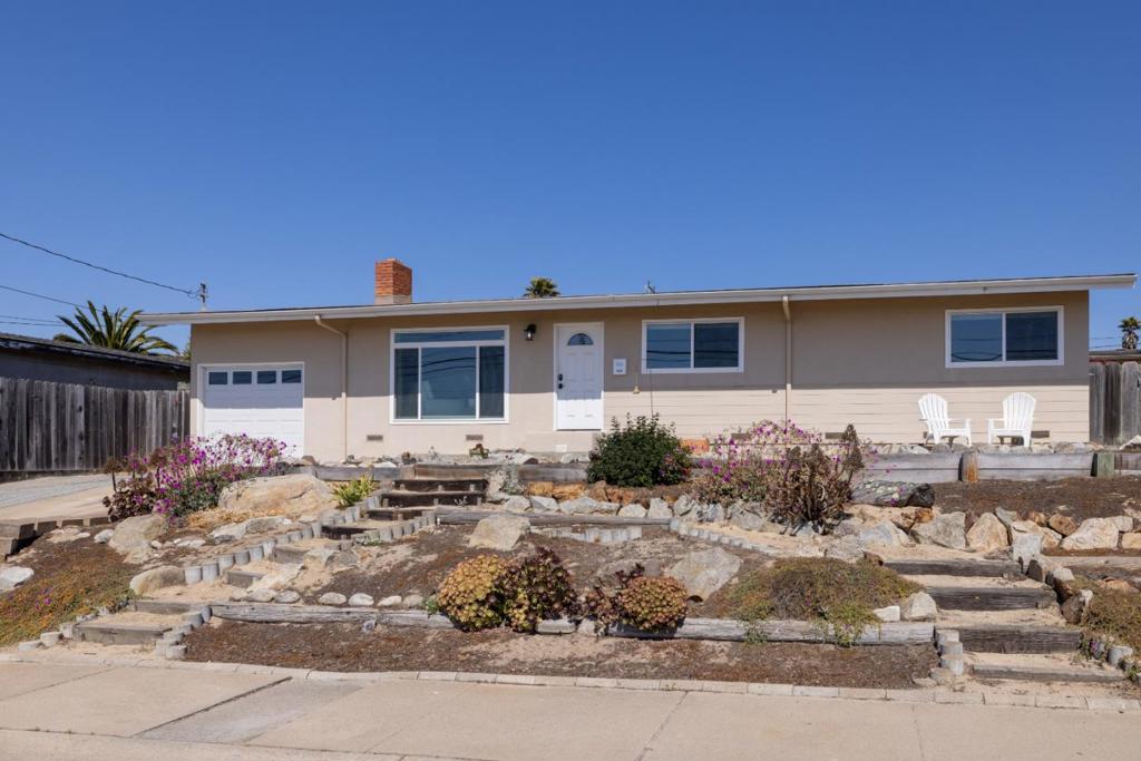 Pass through a natural, low-maintenance garden dotted with native plants and succulents on your way to the front door of this single-level Seaside home. Looking back over your shoulder as you enter, feel your eyes widen automatically as you take in the expanse of ocean blue that stretches to form the background of your attractive neighborhood. A peaceful enclave in Upper Seaside, Ord Grove is your gateway to all the delights of Seaside and the Monterey Peninsula. Book yourself for an afternoon at Bayonet Black Horse Golf Course, or take a restorative stroll along Del Monte Beach. This lovely home will be here to welcome you back from your adventures with a wide array of features and amenities that tell stories of ultimate comfort: a wood-burning fireplace; a galley kitchen with ample cabinetry; gorgeous hardwood flooring; spacious bedrooms; and a big picture window in the living room framing the Pacific. The backyard is a genuine treat. Invite your friends to laugh the night away around a fire pit in the glow of mood lights draped across the branches of mature olive trees. The outdoor spaces manage to strike that elusive balance between artful cultivation and alignment with the natural coastal topography of the area. The person who gets this one is in for a richly rewarding life.