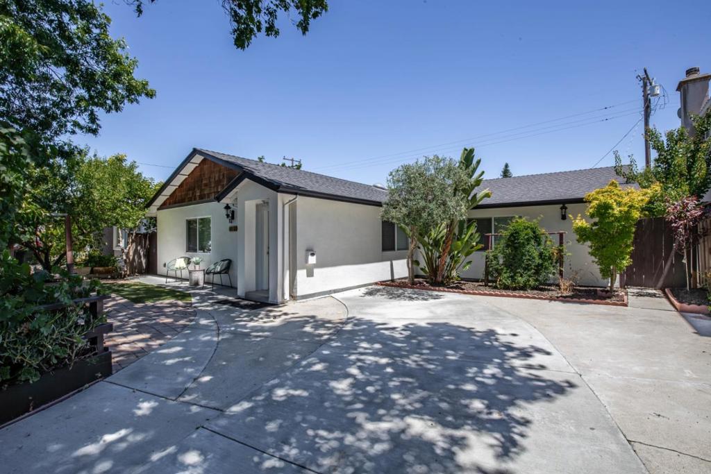 Substantially renovated in 2010 & featuring 1,988 SF of living space. One-story home sits across Apple Spaceship Campus & Cupertino Main Street. Close to top-rated Cupertino schools: Sedgwick Elem, Hyde Mid. Cupertino High. Great curb appeal with a well-kept front yard garden full of flowers, lush plants, trellis, & a concrete brick paver walkway. Greeted by a decorative glass front door into an entryway that opens an interior with high vaulted ceilings & brand new luxury vinyl flooring. Spacious family room. The kitchen is equipped with SS. appliances: refrigerator, dishwasher, oven, cooktop, & hood. It also features granite countertops, quality white chic cabinetry. The primary bedroom boasts soaring ceilings, walk-in closet, & an en-suite bath with a shower, tub, & vanity for a private retreat. Additional bedrooms are generously sized, each with their own closets, while a convenient hallway bathroom features a combined tub & shower with vanity. A guest ensuite adds flexibility for visitors or extended family stays. A spacious backyard offers plenty of room to relax, garden, play, or entertain. This home blends comfort, convenience, easy access to Hwy 280 & Lawrence Expy. & timeless design don't miss this opportunity to own in one of Cupertino's most desirable neighborhoods!