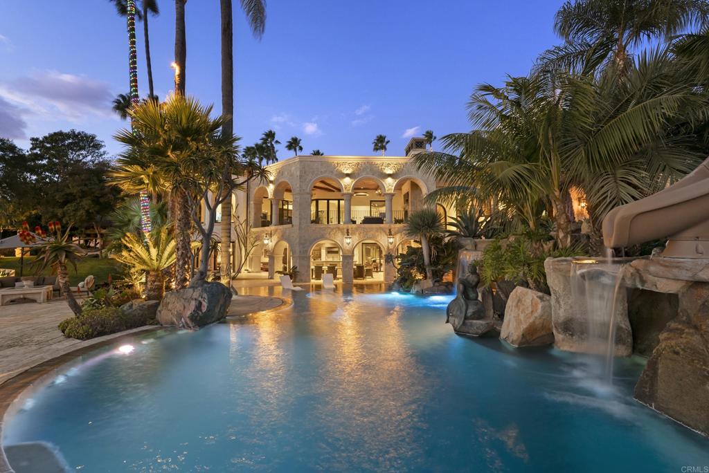 Nestled behind a grand, gated entrance, this private 6-acre Covenant estate in Rancho Santa Fe is a hidden treasure at the end of a secluded drive. Surrounded by meticulously manicured landscaping, soaring palms, flourishing vineyards, and a fragrant orange grove, the property emanates serene luxury. Perched atop one of the highest elevations in Rancho Santa Fe, the six-bedroom estate boasts commanding southwest views of the region, stretching to Black Mountain, UTC, and Mount Soledad in La Jolla. The main residence is an architectural masterpiece, offering four spacious bedrooms, a voluminous office, a walk-in wine cellar, a spa-like primary suite with two boutique showroom closets, and a gourmet kitchen. Perfect for entertaining, the home features an elegant bar, a comfortable family room, a massive game room, and a theater/gym. Outside, the resort-style pool dazzles with its breathtaking size and beauty, setting the stage for unforgettable gatherings. The guest house includes a full living room, kitchen, bedroom, and bathroom for ultimate comfort and privacy. Adding to its charm, there is a paddle court with viewing pavilion and the four-stall barn has been transformed into four luxurious casitas, ideal for hosting guests. A lush grass arena invites both children and adults to play and revel in the property's idyllic surroundings. This estate is a rare combination of privacy, elegance, and sweeping vistas, offering an unparalleled lifestyle in one of Rancho Santa Fes most coveted locations.
