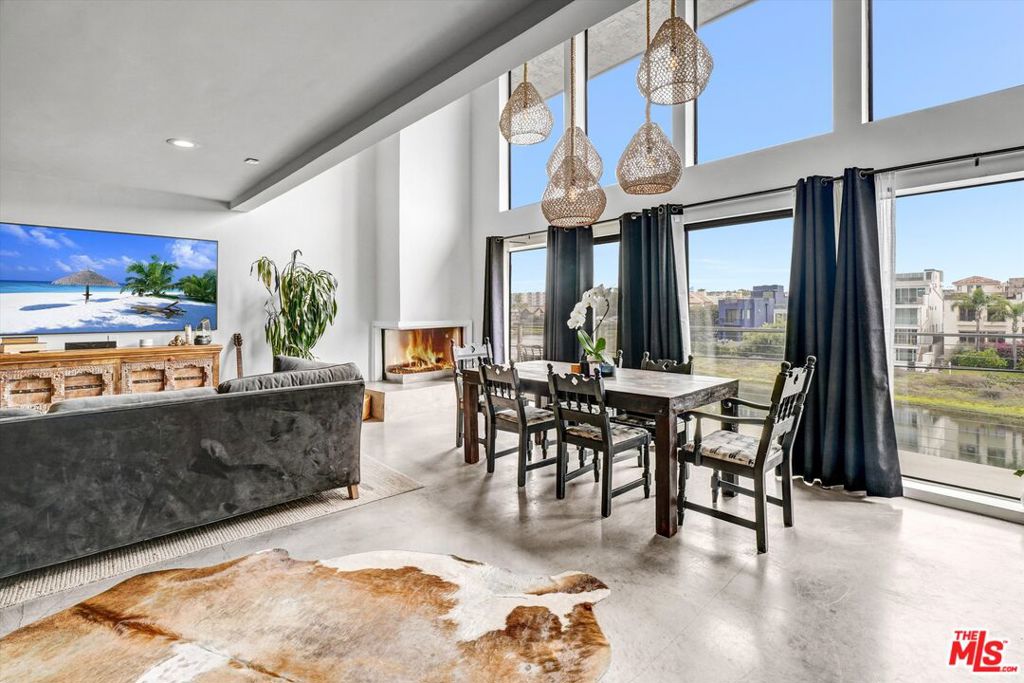 This is your chance to live the dream on the sought after Marina del Rey Peninsula. Located Just steps to the sand, this amazing, three-story town home has great energy and feels fresh and welcoming. Its located in the center of the peninsula offering the ultimate costal lifestyle experience. It is Beautifully furnished and equipped with everything you need to move right in and get busy relaxing. The main living area covers an entire floor with soaring ceilings, floor-to-ceiling windows and glass doors that open out to a sizable balcony with sweeping views of the canal and main channel. Concrete flooring, chic custom lighting, and a sparkly, crystal filled corner fireplace create a warm ambiance. The kitchen includes stainless appliances and sleek counters including an open bar to the dining/living area all which provide a wonderful and functional environment for great entertaining. The two bedrooms are separated nicely on different floors for total privacy. The primary bedroom is spacious, bright and has views of the canal and plenty of closet space. The en-suite, spa-like bathroom has designer tile, a huge, striking, free-standing tub and an even bigger, separate shower. Cool designer wallpaper adds a playful touch of whimsy! The 2nd bedroom is on the top level and has an attached loft which makes a great office area with views for days as well as a large, covered patio/balcony with ocean views where you can enjoy the sun set every night! Two-car gated, garage with direct access makes this the perfect luxury beach pad. A completely separate but attached studio may be available for additional rent. Please call for more info.