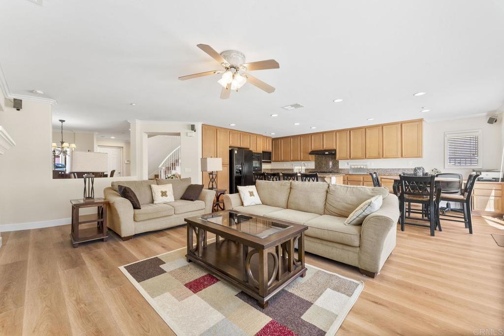 Enjoy serene hillside views from the privacy of this upgraded Highlands Ranch home with owned solar! Nestled on a premium lot along a cul-de-sac with no neighbors behind, this residence overlooks open space from the back and sweeping valley vistas from the front. This home is move-in ready with brand new flooring (LVP and carpet) and fresh paint throughout. The flexible floor plan includes and optional 5th bedroom and a full bath on the first floor - excellent for hosting or multi-generational living. The spacious family room flows seamlessly into the open-concept kitchen with a center island, granite countertops, and brand-new dishwasher and range hood. A separate living and dining room near the front entry offer architectural character with curved walls and two-story ceilings. The attached 3-car garage is thoughtfully split (2-car + 1-car) to provide ample parking, storage, or potential for a workshop or home gym. Upstairs, the expansive primary suite showcases stunning views, two walk-in closets, dual vanities, and a separate soaking tub and shower. Outside, this home is meticulously landscaped, with low-maintenance turf in the front and lush grass in the back. The HOA offers access to resort-style amenities including tennis and basketball courts, and a pool. This home is conveniently located near freeway access and within 25 minutes of Downtown San Diego, beautiful beaches, the bay, and Coronado Island.