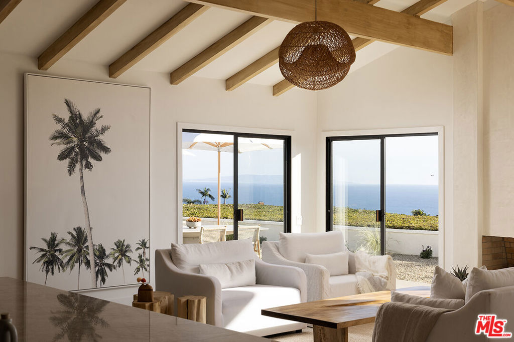 Nestled in Malibu's coveted Big Rock neighborhood, 20374 Seaboard is a newly renovated single-level Midcentury Ranch that epitomizes coastal luxury. With breathtaking panoramic views of the Pacific Ocean, Catalina Island, and the iconic Queen's Necklace, this home offers an unparalleled living experience designed for seamless indoor-outdoor flow. The open-concept floor plan is enhanced by soaring beamed ceilings, abundant natural light, and warm wood flooring custom-installed to perfectly complement the space. The heart of the home is a chef's kitchen featuring a spacious island, Taj Mahal quartz countertops, and top-of-the-line Thermador appliances, including dual dishwashers, a wine refrigerator, and a beverage fridge. The kitchen flows effortlessly into the great room, where a cozy fireplace and sliding glass doors open to an expansive ocean-view patio, creating an entertainer's dream. The primary suite is a tranquil oasis, captivating ocean vistas, spa-inspired amenities, and a waterfall shower with dual glass doors leading to a lush open-air bath-tub retreat. Three additional bedrooms, a convertible office/den, and a fully equipped utility room provide flexible and functional living spaces. Surrounded by mature olive trees, lavender, and manicured landscaping, the 11,743-square-foot lot features a brand-new drip irrigation system for effortless maintenance. Modern comforts include WiFi-enabled appliances, a 5-ton HVAC system with all-new ducting, and tasteful LED lighting throughout. With parking for six, including a 2-car garage, and security features like motion-activated lights and Ring cameras, this home combines convenience with peace of mind. Located just minutes from Malibu's iconic beaches, upscale dining, and the vibrant hubs of Pacific Palisades and Santa Monica, 20374 Seaboard offers a rare blend of luxury, privacy, and accessibility. This is Malibu living at its finest.