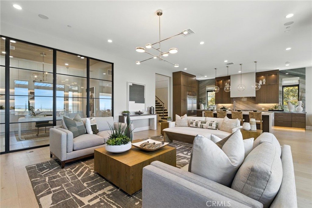 Pinnacle at The Summit at Orchard Hills by Toll Brothers – Homesite 0019. Experience refined luxury with the Addis floor plan, Italianate exterior, 5 ensuite bedrooms, 5.5 baths, approx. 4,579 sq. ft. of living space on a 6,483 sq. ft. homesite, with 2-car garage and pool-sized backyard. This rare single-loaded street offers privacy with no direct front or rear neighbors, while elevated city-light views extend toward Newport and Catalina Island. Designed for modern living, the home features a cantilevered steel floating stair with glass railing, 22’ stairwell ceilings, glass walls in flex spaces, and multiple Western multi-slide stacking doors for seamless indoor/outdoor living. Additional highlights include a downstairs suite and office, loft, 60” Primo fireplace, Wolf® and Sub-Zero® appliances, spa-inspired primary bath with Kohler® digital shower system, floating vanities with LED lighting, designer electrical and low-voltage selections, and a private primary suite deck. Estimated completion is Summer 2026, presenting a limited opportunity in Irvine’s most desirable staff-gated hillside community. Residents enjoy access to resort-style amenities, saltwater pools, parks, and acclaimed Irvine schools. Buyers still have time to personalize cabinets, countertops, and flooring. Photos are of the model home; actual home is under construction.