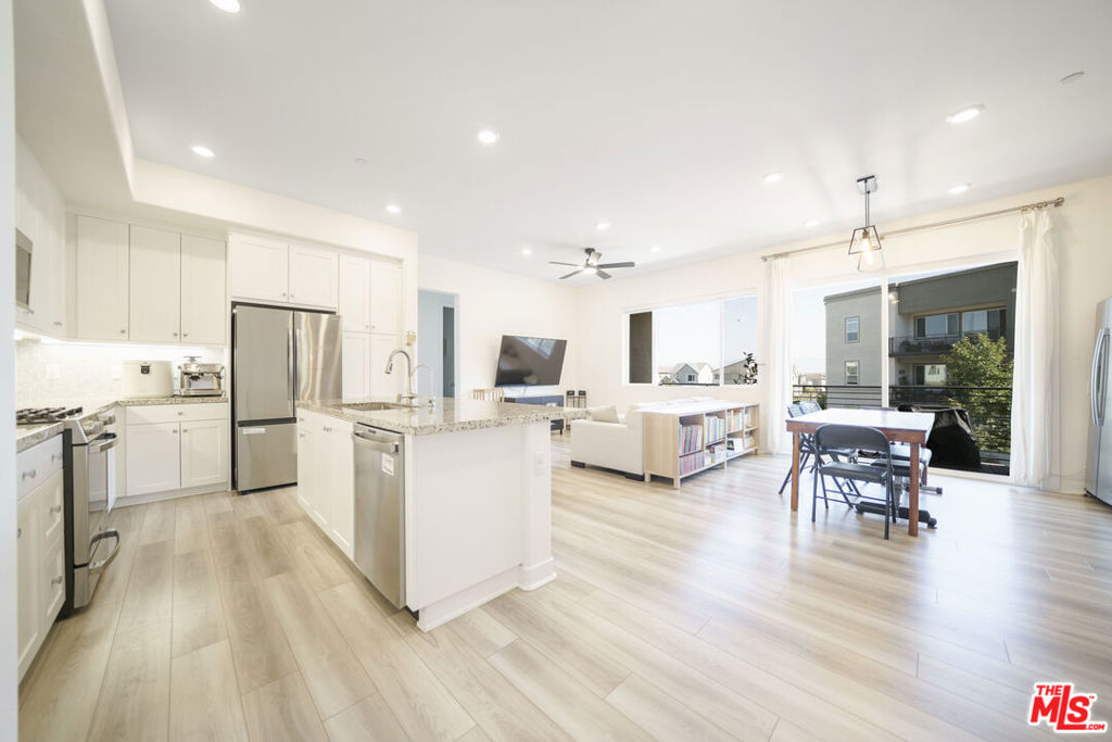 Welcome to a meticulously maintained, like-new residence in a beautifully designed eco-friendly community. Originally built in 2022 and thoughtfully improved by its current ownersMr. and Mrs. Clean themselvesthis single-level gem is nestled within a three-story building and offers the perfect blend of style, function, and comfort in one of the area's top-rated school districts.The home features a spacious open-concept floor plan that seamlessly connects the kitchen, dining, and living areas, drenched with natural light. High-quality laminate flooring runs throughout the bedrooms and main living spaces, adding warmth and sophistication. The kitchen is equipped with sleek granite countertops and a large center island offering ample cabinet storageperfect for both daily living and entertaining. Just beyond the dining area, a sliding glass door opens to a generously sized balcony where you can unwind and take in breathtaking sunset views over the mountains.The primary suite is a serene retreat, complete with a spa-inspired bathroom featuring elegant double vanities. All windows throughout the home offer a peaceful view of the beautifully landscaped and maintained courtyard, creating a sense of privacy and calm. The home also includes a side-by-side two-car garage with additional space for storage, along with a dedicated EV charging station to accommodate your electric vehicle needs.This residence is powered by solar energy, significantly reducing electricity costs while contributing to a greener lifestyle. Residents enjoy access to an array of resort-style amenities, including a sparkling community pool, clubhouse, playground, bike track, lush gardens, and scenic walking trails. This is a rare opportunity to own a turnkey home that offers all the benefits of new construction, enhanced by thoughtful upgrades and pristine upkeep. Come experience a lifestyle of comfort, convenience, and modern elegance - schedule your private showing today.