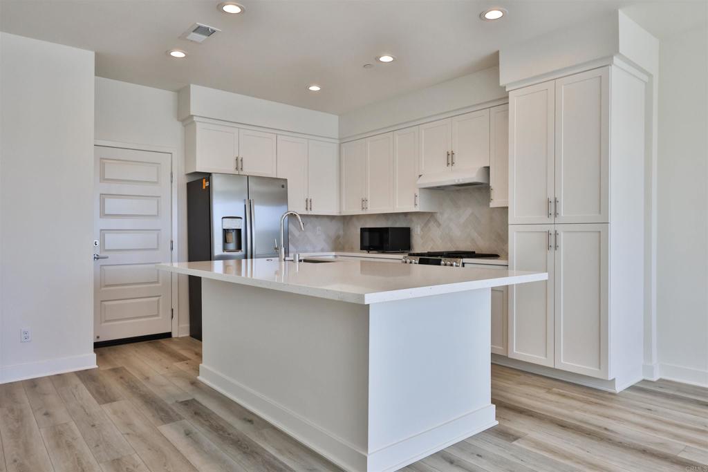 Newer construction home in the vibrant 3 Roots Community, bordering Mira Mesa and Sorrento Valley. 2 story townhome featuring an open concept design, gourmet kitchen, smart home features, and high end finishes. This home sits on a premium lot with no neighbors in front and tons of natural light! Luxury vinyl flooring throughout with carpet in the bedrooms. The kitchen is appointed with quartz countertops, stainless steel GE appliances, a beautiful modern herringbone backsplash, and white cabinetry. 2 car garage with built-in storage racks and an EV charging outlet available. Smart home upgrades include Ring doorbell, Wifi garage door opener, high speed wifi and fiber optic cable, and Honeywell Wifi Thermostat. This home will keep your utilities low - you have a 3.0kw solar system, LED lighting, insulated dual pane windows and a tankless water heater. You also have a whole house water purification system and HEPA air filtration. Full size washer/dryer in a dedicated laundry room upstairs. The 3 Roots community features over 200 acres of preserved open space, walking and biking trails, multiple parks, state of the art fitness and rec center. Excellent location in West Mira Mesa/Sorrento Valley. Just 17 miles north of Downtown and a short drive to the coast. Easy access to the 5, 805, and 15 freeways. Highly rated schools: Jonas Salk Elementary, Challenger Middle School, and Mira Mesa High School. Make this home yours!