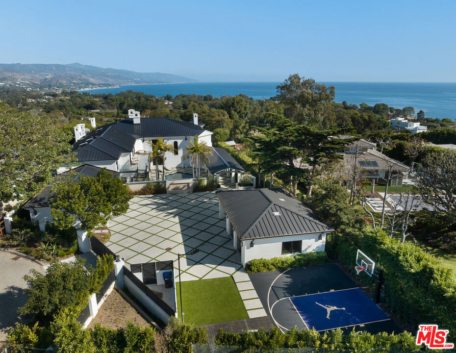 Explore sophistication and serenity in this highly secluded Point Dume retreat. Meticulously renovated both inside and out, this residence boasts exceptional quality, breathtaking finishes, lofty ceilings, and captivating ocean and mountain vistas throughout. Approach the residence through a private front gate leading to a motorcourt with abundant guest parking and two garages, providing covered space for up to 5 cars. A lengthy covered walkway guides you past a delightful pool, spa, and sun deck. The main level of the property features a grand two-story foyer, a fireplace-adorned living room, a formal dining room, a family room with a fireplace and built-in bar, a dual-sided aquarium, a library/office, a chef's kitchen equipped with top-tier appliances, a butler's pantry, a spacious breakfast room, and a stunning outdoor entertainer's patio overlooking the ocean, and more. The upper level comprises 5 bedrooms and a laundry room, with the primary suite offering ample space, ocean views, a fireplace, a private terrace, a custom walk-in closet, and a lavish bath. The lower floor includes a movie theater, a gym with a bathroom, a safe room, and a second laundry room. Additional amenities encompass a staff suite with a kitchenette, along with a built-in BBQ, firepit, and putting green. This residence epitomizes the pinnacle of "beach living," delivering luxury, comfort, and seclusion.
