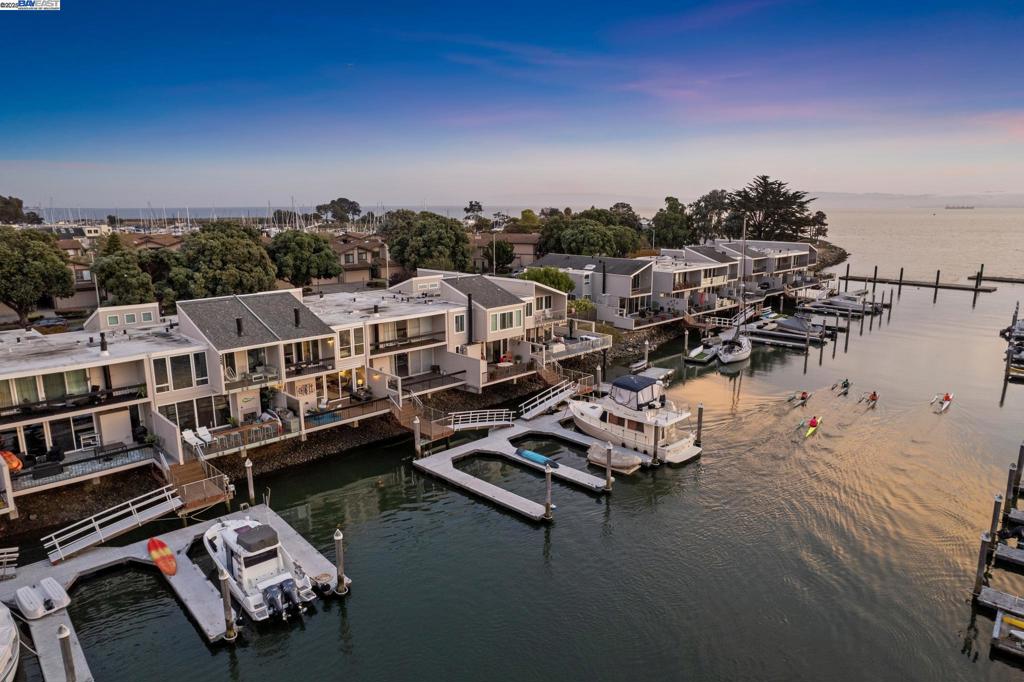 A rare waterfront opportunity on Alameda’s coveted Ballena Bay, this upgraded 4BD/2.5BA contemporary townhome offers exceptional island living with a private deep water boat slip. From the enclosed front patio, step inside the 2452 SQFT home’s spacious and flexible living area, beginning with a large eat-in kitchen and den. Nearby, the formal dining room is connected with a passthrough to the kitchen. Dine with a view of the bay framed by the wall of windows and glass doors in the adjacent living room. Open the doors onto the deck to relax with family or entertain friends with calming waters all around you and your own private dock just steps away. The home’s lower level is complete with a powder room, laundry room with sink, and interior access to the garage. Gorgeous hardwood floors span upstairs where two sunny bedrooms with custom closets share a full bath with a dual vanity. One has glass doors onto a front balcony. Currently configured as a huge primary suite, a wall in the third bedroom can be restored to create a fourth. The rooms have fabulous bay views, and the primary bedroom has an ensuite bath, walk-in closet and a deck. Explore the vibrant island life including: Webster Street, farmers market, the ferry, Transbay bus, Crown Beach, great schools, and shoreline trails