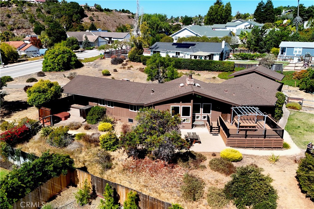 This sprawling single-level residence offers 3 bedrooms, a versatile bonus room, an office nook, and 2.5 bathrooms. Step inside to a grand entry featuring a centerpiece floor-to-ceiling rock fireplace, expansive view windows, and a spacious living room filled with natural light. The kitchen features an island, breakfast nook, abundant storage, a newer Jenn-Air oven, and a Fisher & Paykal gas range. Just beyond, you’ll find a convenient powder room and a bonus room. On the western wing of the home is a separate laundry room, two guest bedrooms, a full bath, and primary suite with vaulted ceilings and direct access to the spa and side yard. The property also boasts an oversized two-car garage and a high-ceiling carport ideal for a boat or RV. Enjoy outdoor living with multiple gathering spaces, including a composite deck with bar, a lawn, citrus trees, low-maintenance landscaping, and a tranquil spa retreat. The front yard offers exciting potential, whether you envision additional structures, a vegetable garden, or a flourishing fruit orchard. Located just minutes from the charming Arroyo Grande Village, this custom home is ready for you to make it your own.