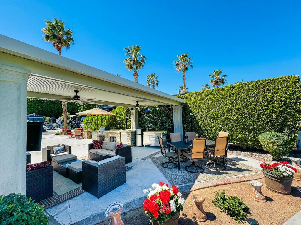 Nestled in a serene and private setting, this premium Class A RV lot offers the ultimate retreat with an expansive, unobstructed view of the lush golf course. Wake up to the perfect morning sun and enjoy the peaceful ambiance created by long privacy hedges on both sides. A solid-roof Alumawood pergola provides shade and comfort, complemented by two ceiling fans to keep you cool as you relax outdoors. Thoughtful landscaping enhances the beauty of the space, while a mounted outdoor TV lets you unwind in style. The lot is equipped with a solar-powered security camera for added peace of mind, and manual shades provide customizable privacy. Located just steps from the satellite pool, sauna, hot tub, showers, and laundry facilities, this property blends luxury, convenience, and community in an exclusive resort setting.Designed for both relaxation and entertaining, this lot features a well-appointed medium-sized outdoor kitchen with a dishwasher, burner, built-in BBQ, hot water, and a fridge--perfect for cooking and dining al fresco. Additional amenities include extra storage containers, two rolling storage carts, and two umbrellas to enhance your outdoor living experience. A negotiable golf cart, recently upgraded with new batteries last November and a protective cover, adds ease and convenience for exploring the resort. Whether you're seeking a quiet retreat or a vibrant social atmosphere, this property provides the perfect balance of privacy, luxury, and friendly community living for discerning Class A RV owners.‍Outdoor Resort Indio is a Class A RV resort.