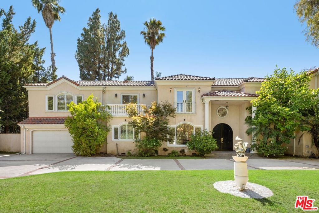 Stunning gated estate located South of the Blvd on prestigious Vanalden Ave. This private and stately home offers soaring vaulted ceilings, dramatic dark wood floors, and an open layout ideal for entertaining. The grand living room features floor-to-ceiling windows creating an abundance of natural light with views of lush greenery and a sparkling saltwater pool. A dramatic second-floor mezzanine overlooks the spacious living room, adding architectural elegance and a sense of grandeur. The home includes a formal dining room, cozy den with fireplace next to the kitchen, and a separate sitting or game room off of the living room. The chef's kitchen boasts high-quality Imperial appliances, a built-in refrigerator, stone counters, center island, and a breakfast nook with French doors leading to a resort-style yard. The backyard oasis includes a heated pool and spa, built-in BBQ, gazebo, fire pit, and child safety gate. The first floor has two bedrooms, offering an ideal spot for an office. The second floor features four large bedrooms, including a luxurious primary suite with dual walk-in closets, a spa-style bath with steam shower, jetted tub, and marble finishes. One bedroom serves as a home theater with balcony access completing the upper level. This is a unique opportunity to own a beautifully designed residence in one of the most sought after areas in Tarzana.