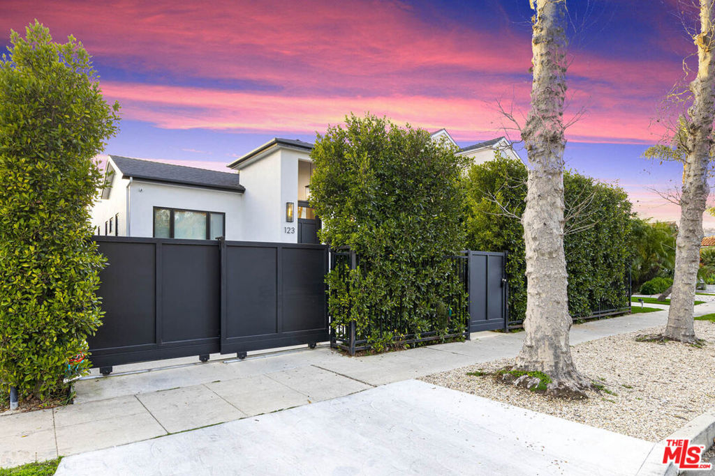 You Can Have It All at 123 S. Kilkea Drive. A home that proves elegance and ease, luxury and livability, privacy and prime location does not have to be a trade-off. You truly can have it all! Tucked behind tall privacy hedges on one of the most picturesque, walkable streets in Beverly Grove, this single-story modern farmhouse feels like a private resort compound in the middle of the city. Built by a Trousdale Estates builder, the home delivers the exceptional craftsmanship and refined details typically found in Beverly Hills yet offered here at a rare value. From the moment you arrive, a sense of calm and sophistication sets in. Step through the oversized 9-foot pivot door and enter a sunlit space where wide-plank white oak floors, 10-foot ceilings, and warm modern finishes invite you to relax and stay awhile. The thoughtful layout flows effortlessly from formal living to dining, kitchen, and family room, creating spaces that are both elevated yet utterly comfortable. At the heart of the home lies the stunning entertainer's kitchen, anchored by a 12-foot double waterfall island with seating on both sides. With custom cabinetry, a walk-in pantry with pull-out shelving, high-end appliances, and designer brass hardware, this space was made for connection whether you're cooking for two or entertaining a crowd. Adjacent, the family room is layered with texture and intention: a striking architectural wall blending wood and tile, a built-in wine rack, space for a wine cooler, floating shelves illuminated by soft LED lighting and a focal fireplace. The result is a stylish, yet relaxed atmosphere conveyed throughout the residence and grounds. The primary suite is a true retreat, featuring two artfully lit walk-in closets with built-in LED accent lighting that make the space feel like a luxury boutique where you can relax while surrounding yourself in a beautiful space with your favorite things. The spa-like bath completes the retreat with its clean lines, elegant finishes, and calming palette. Once outside, your private outdoor oasis continues. The backyard offers a seamless blend of deck, pool, spa, and green space. All framed by mature hedging that enhances the feeling of exclusivity. Whether relaxing in the sun or hosting under the stars, the space is designed for year-round enjoyment. Adding flexibility and long-term value is a fully detached guest house/ADU complete with its own address, bath, and kitchenette. Use it as a private guest suite, gym, studio, or WFH office, the possibilities are endless. There is also a dedicated laundry room offers ample storage with abundant cabinetry, a deep utility sink, and plenty of space to keep daily routines organized and out of sight. Other highlights include: 8-foot solid-core interior doors, Jeld-Wen windows, The Shade Store motorized window treatments, Linear slot A/C vents, Sonos sound system, plus a rare 100 sq ft California basement for additional storage. Completed in 2022, 123 S Kilkea is more than just a home, it's a turnkey lifestyle, where every detail has been curated for comfort, beauty, and ease. Whether you're seeking a forever home, downsizing in style, or upgrading to refined single-level living, this property is the one you've been waiting for. Here, you're just moments from the best of Melrose, West 3rd, and The Grove, with a 94 Walk Score and a vibrant neighborhood allowing you to relish the benefits of a city lifestyle while creating community roots. This is where form meets function. Where luxury meets livability. Where privacy meets location. This exceptional home is where you can have it all.