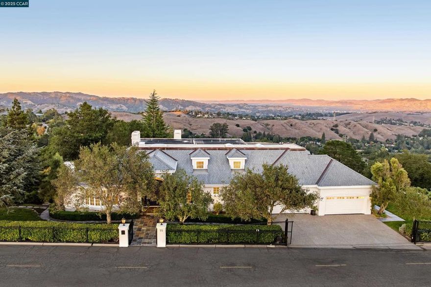 Perched atop the Orinda Oaks Open Space Preserve, this estate offers sweeping views of Mt. Diablo and the Berkeley hills. Mature oaks, Japanese maples, wisteria, lavender, roses, and other lush foliage flank the home. Step inside the foyer beneath 15-foot ceilings. To the left, a 360-sq-ft living room sits under a coffered ceiling; to the right, the dining room accommodates 10-12 with garden views. The kitchen features a large island with bar seating, a breakfast nook nestled into a bay window, 2 ovens, 2 sinks, 2 dishwashers, and ample counter space. Adjoining the kitchen, the family room spans more than 360 sq ft and includes a full wet bar. A 240-sq-ft office and large wraparound patio offer inspiring views—including glimpses of SF Bay. Four bedrooms are on the lower level, including a private guest/in-law suite or exercise room. The 460-sq-ft principal suite upstairs offers a marble fireplace, 2 walk-in closets, a nursery or exercise room, and a luxurious bath with steam shower, jacuzzi tub, sauna, dual vanities, and skylights. Outdoor living is equally distinguished with a covered swimming pool, built-in grill, and pergola-shaded lounge area with a new gas firepit overlooking the Preserve’s natural splendor.