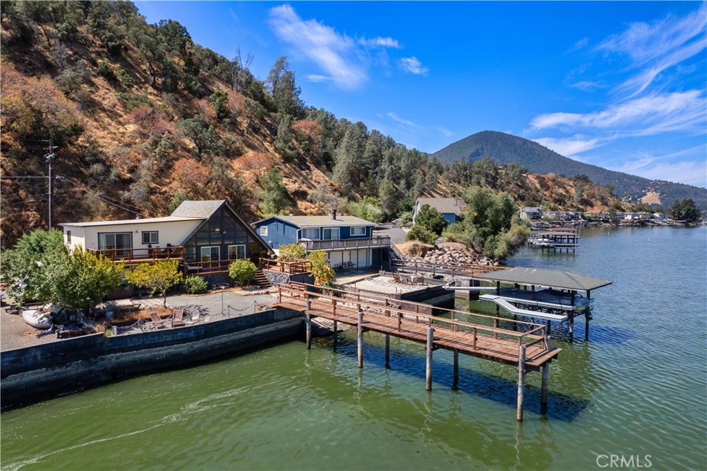 Discover the ultimate escape in this enchanting split-level home nestled on the serene shores of Clearlake, within the coveted Indian Gardens community on Windflower Point. This picturesque lakefront A-frame style home offers the perfect blend of casual living and year-round comfort, ideal for both vacation getaways and permanent residence. Boasting 3 bedrooms, 2 bathrooms, PLUS a loft that offers expansive views of the sparkling lake. Enjoy the open-concept living and dining area with vaulted ceilings that enhance the natural light and provide a sense of airy spaciousness. The ground floor offers the main living spaces, one bedroom, a bathroom, and a laundry room. On the mid-level, you'll find 2 guest bedrooms, a deck, and a bathroom. Upstairs, is the main attraction loft, equipped with built-ins, where the lake is always part of the scenery. New floors throughout. Step outside to embrace the peaceful lakefront living you’ve always dreamed of. The property includes a pier, a boat storage with a pulley system, three separate decks, a private hot tub, and multiple sitting areas! Lake living at it's best!