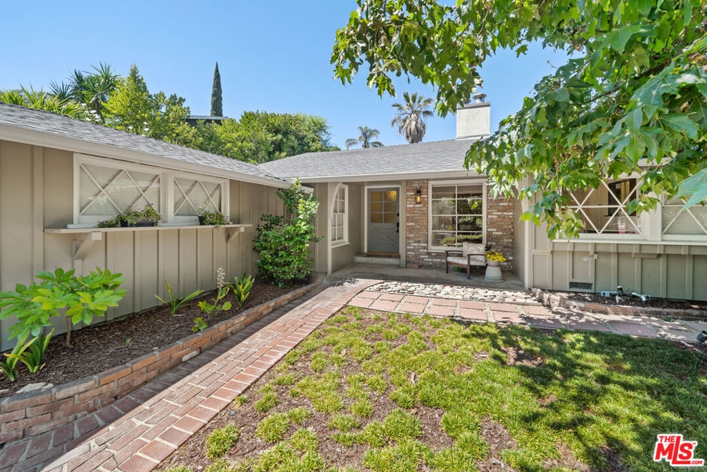 Located south of Ventura Boulevard on a quiet street in the hills of Sherman Oaks, this traditional-style home features four bedrooms, a spacious family room, and an open living room with high wood-beamed ceilings. The interior includes hardwood floors, two fireplaces, and a remodeled kitchen with a breakfast area and an adjoining dining room. All bathrooms have been updated, and the primary bathroom offers a soaking tub, dual vanities, and a walk-in glass shower. Sliding doors from both the living and family rooms open to a peaceful backyard with a patio and landscaped gardens. Three bedrooms are located downstairs, while the fourth is upstairs and includes beautiful city light and canyon views and a private bathroom nearby. Additional amenities include an indoor laundry room, a guest bathroom, and a two-car garage suitable for parking or storage.