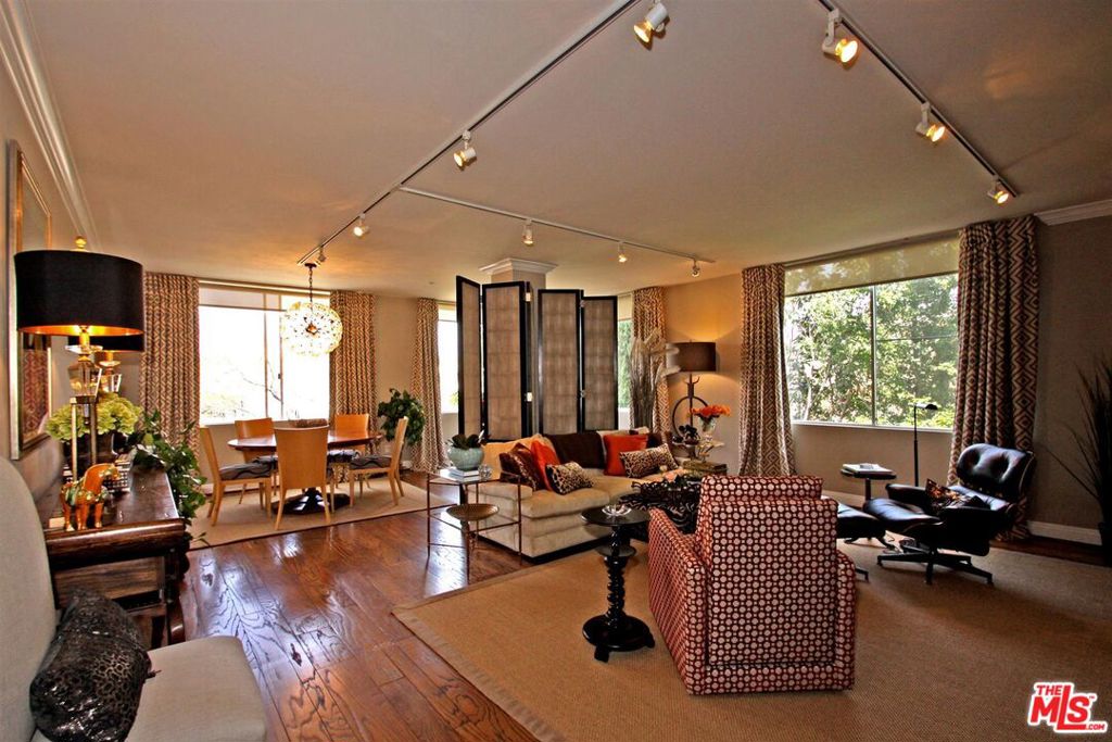 Stunning, light, bright, single level, 4th floor front corner condo in the heart of Beverly Hills! Decorator-perfect, each detail has been finely crafted to create a sophisticated, yet comfortable living environment. Beautiful foyer entrance leads to wall-to-wall picture windows, providing lovely tree top & mountain vistas streaming in. Distressed hardwood floors, (carpet in bedrooms) with custom window treatments throughout. Open floor plan living room with custom bookshelves flows to dining room. Remodeled kitchen w/ granite counters, stainless steel appliances, and eat-in breakfast rm. Luxurious, large master bedroom with custom walk-in closet, marble & granite bath w/separate tub and shower, and double vanities. Spacious, beautifully appointed second bdrm. Exquisite, dramatic powder room. Fab. Beverly Hills location - Walk to all Beverly Hills and WeHo shops & restaurants. Secure 2 car parking & entrance. Washer & dryer in unit. Beverly Hills School District!