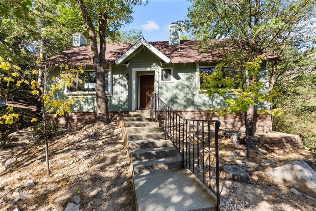 Surrounded by towering trees, this home delivers space, flexibility and the perfect setting for a custom mountain getaway. This 2,619-square-foot property features 3 bedrooms, 3.5 bathrooms and sits on a 17,820-square-foot lot. Inside are open living and family room areas with two brick fireplaces, a spacious kitchen and dining area, upstairs and downstairs primary suites, a bonus room or office that could serve as a fourth bedroom, central heating, a laundry area and abundant storage. The outdoor spaces include a deck, gazebo, side and backyard areas ideal for relaxing or entertaining. Additional features include double-pane windows, public utilities, a two-vehicle carport and off-street parking. Just minutes from the lake, golf course and national forest, this home offers the chance to move in now, enjoy the mountain lifestyle and update over time to make it your own. Less than two hours from Los Angeles, Orange County and San Diego, it’s an ideal full-time residence, weekend retreat, or vacation rental. Don’t let this opportunity pass you by!