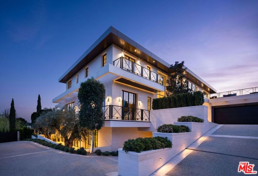 This newly completed approx. 17,000-square-foot estate in Brentwood is the debut Los Angeles development designed by internationally acclaimed AD100 Hall of Fame firm, Ingrao Inc. Inspired by the architectural grandeur of the Getty Museum, the residence is clad in timeless limestone, accented by sweeping travertine pavilions and a stately bronze roof. Positioned on a private, gated, and sprawling lot, the home offers sweeping views of the Pacific Ocean and panoramic views of the Getty and the city. Crafted with the highest caliber of design and materials, the estate features 7 bedrooms and 14 bathrooms arranged across three levels, connected by a sculptural staircase and private elevator. The primary suite is a true retreat, boasting dual baths, dual walk-in closets, and a vast ocean-facing balcony. With an art gallery, auto gallery, and a main floating staircase that acts as a complex structure of art, the home was designed for a collector who enjoys elevated living and exceptional entertaining. A rooftop deck offers 360-degree views, a firepit, and a bar, while the state-of-the-art movie theater, indoor/outdoor wellness center with gym, sauna, steam room, and cold plunge bring resort-level luxury into daily life. Outdoor amenities abound: a serene pool with Baja shelf and spa, a pool house with built-in BBQ, a fire pit encircled by mature strawberry trees, and an expansive presidential-like flat lawn framed by sycamore trees and landscaping curated by Will Bailey, formerly of Christine London, to harmonize with the estate's refined architecture. Additional features include a a 2-car main-level garage, an 8-car subterranean garage with a dedicated security room, and infrastructure for a guard booth at the entry gate. Every element of this estate has been meticulously considered to deliver an unmatched lifestyle, an architectural and design tour de force in one of Los Angeles' most coveted enclaves.
