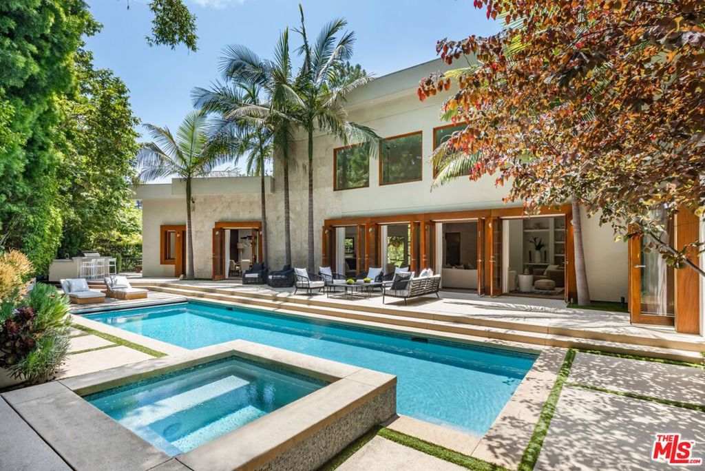 A contemporary estate nestled behind a long, gated driveway in prestigious Holmby Hills. This architectural home opens to a two-story living room with gallery lighting, skylights, and floor-to-ceiling windows framing lush, park-like grounds with pool, spa, and large deck on half an acre. The open floor plan seamlessly connects the dining room, family room, and sleek chef's kitchen with top-tier appliances. Upstairs, the primary suite offers a fireplace, a spacious balcony, a walk-in closet, and a spa-like bath. 5 bedrooms and 5.5 baths offer ample space for family and friends. Thoughtful details throughout include jade and Jerusalem stone, maple floors, and textured walls. House is equipped with a full-house generator, top of the line window break protection on all glass doors and windows, plus shutters that close at night. Large motor court and 3 car garage offer plenty of parking space. Ideally located near Harvard-Westlake Middle School, offering convenience and prestige. Also available for sale $9,950,000.