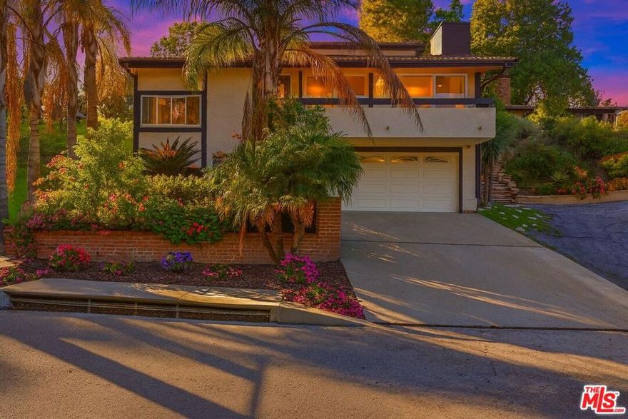 Welcome to this serene Woodland Hills retreat, set on a quiet, tree-lined street south of the boulevard. This beautifully maintained split-level home blends privacy, space, and comfort with soaring ceilings and expansive natural light throughout. Recently refreshed with new hardwood floors, the home features a bright living area with dramatic volume, a cozy family room with a fireplace, and a spacious kitchen with granite counters and a breakfast nook. The layout offers three generous bedrooms and three bathrooms, including a primary suite with its own fireplace, walk-in closet, and French doors that lead to a covered brick patio and private yard. Multiple outdoor spaces create effortless indoor/outdoor living perfect for relaxing, working from home, or hosting quiet evenings under the trees. Additional highlights include inside laundry, updated lighting, ample storage, and a detached garage. Minutes from Ventura Blvd shopping and dining, hiking trails, and top Woodland Hills amenities, this home delivers privacy and convenience in one of the area's most peaceful pockets. Ready for immediate occupancy.