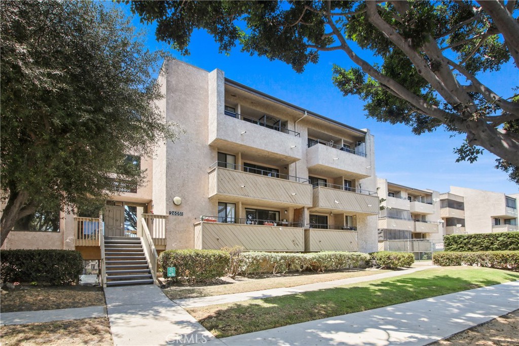 LOCATION! CONDITION! And a PRICE that won’t break the bank! It’s all here in this move-in ready condo! This home is light, bright and airy, and feels much more spacious than you would think! As you enter, your eyes will go straight to the “green” of Ken Malloy Park which is directly across the street! There’s lots of room to spread out in your spacious living room which leads out to a private balcony overlooking the community pool and spa. The dining room adjoins the kitchen, which is well-appointed with stainless appliances, lots of cabinet space and plenty of counter space too! Beautiful coastal gray laminate floors run through all the living areas. The primary bedroom is quite large and features a walk-in closet! The secondary bedroom is also a generous size and has a big wall closet. Both bedrooms have ceiling fans, recessed lighting, and new wall-to-wall carpeting. The bathroom has just been updated with a new bathtub and enclosure, new fixtures and a new low-flow toilet. No need to drag the laundry anywhere, as you have a side-by-side laundry area right in your unit! A mini-split heat/air system keeps you comfortable year-round. Parking won’t be an issue either, as you have a full 2 car side-by-side private garage in close proximity to your unit. The elevator makes it easy to get the groceries in! Spend what’s left of your summer lounging by the pool or soaking in the spa. If nature is your thing, cross the street and spend the day at the park – have a picnic by the lake or take a nice hike! The location is super convenient- close to all major roads, medical care, freeway access and lots of stores! Come take a look and let’s make a deal!