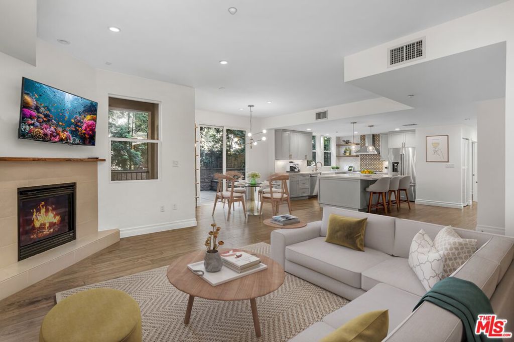 Step into this beautifully designed 1,580 sq ft residence and experience a rare blend of luxury, comfort, and prime location. Featuring 3 generously sized bedrooms and 2 elegantly renovated bathrooms, this light-filled condo offers the perfect canvas for both everyday living and stylish entertaining.The heart of the home is a chef-inspired island kitchen, outfitted with gleaming marble countertops and modern finishes an inviting space to host, create, and gather. Flowing seamlessly from the kitchen, the open-concept living area is anchored by a statement fireplace, ideal for cozy evenings or effortless socializing.Enjoy moments of calm in the serene outdoor common space, a peaceful retreat tucked within the vibrant energy of the city.Situated in one of LA's most sought-after neighborhoods, you'll find yourself just moments from acclaimed restaurants, shopping, and nightlife all while e