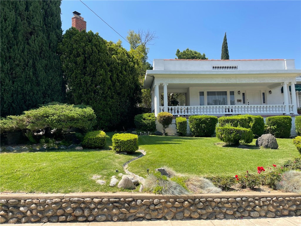 Discover timeless elegance in this beautifully maintained three-bedroom, two-bathroom home in the heart of Pasadena. Built in 1923, this charming single-level residence offers approx. 1,661 sq ft of living space on a spacious 7,981 sq ft lot. A stately façade with classic columns, balustrade railings, and a wide front porch welcomes you to relax and enjoy the peaceful, tree-lined street.
Inside, the sunlit layout features spacious living and dining rooms with original character and a cozy fireplace, offering warmth and charm. The well-proportioned bedrooms provide comfort for family or guests, while the kitchen offers exciting potential for updates.
The backyard is a private oasis with a large covered gazebo, tiled patio, and beautifully landscaped gardens with winding stone pathways — perfect for entertaining or quiet afternoons. A detached one-car garage and gated driveway complete this exceptional property, set in one of Pasadena’s most desirable neighborhoods near shops, dining, and cultural landmarks.
This is a rare opportunity to own a piece of Pasadena history with classic architecture and a magical outdoor retreat.